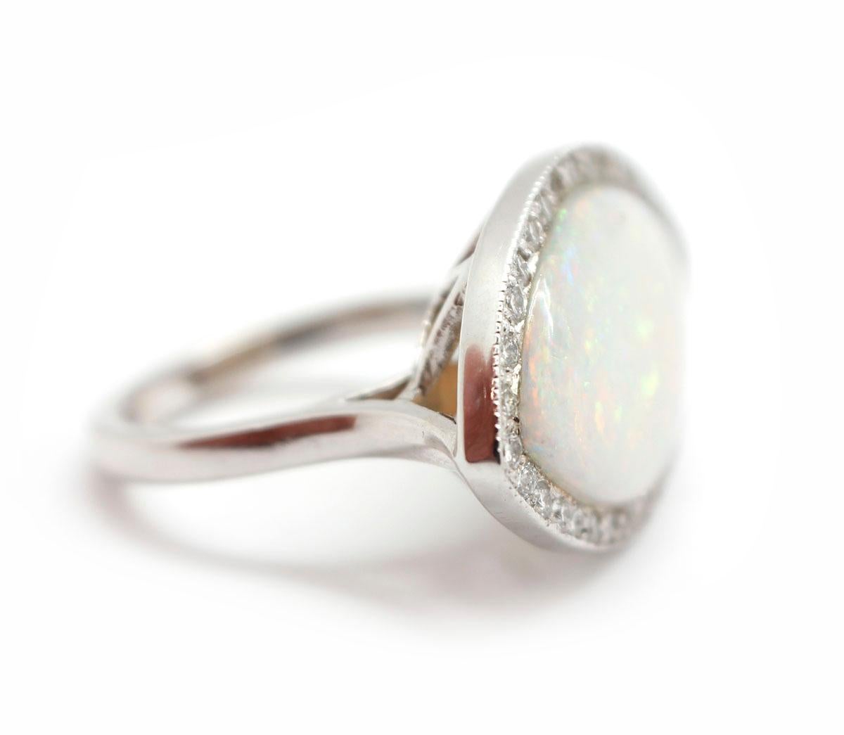 This one of a kind ring is made in 14k white gold. It features a marquise-cut opal in the center of a diamond bezel. There are 32 diamonds for a total weight of 0.32ct. The stones are graded G-H in color and VS-SI in clarity. The ring measures
