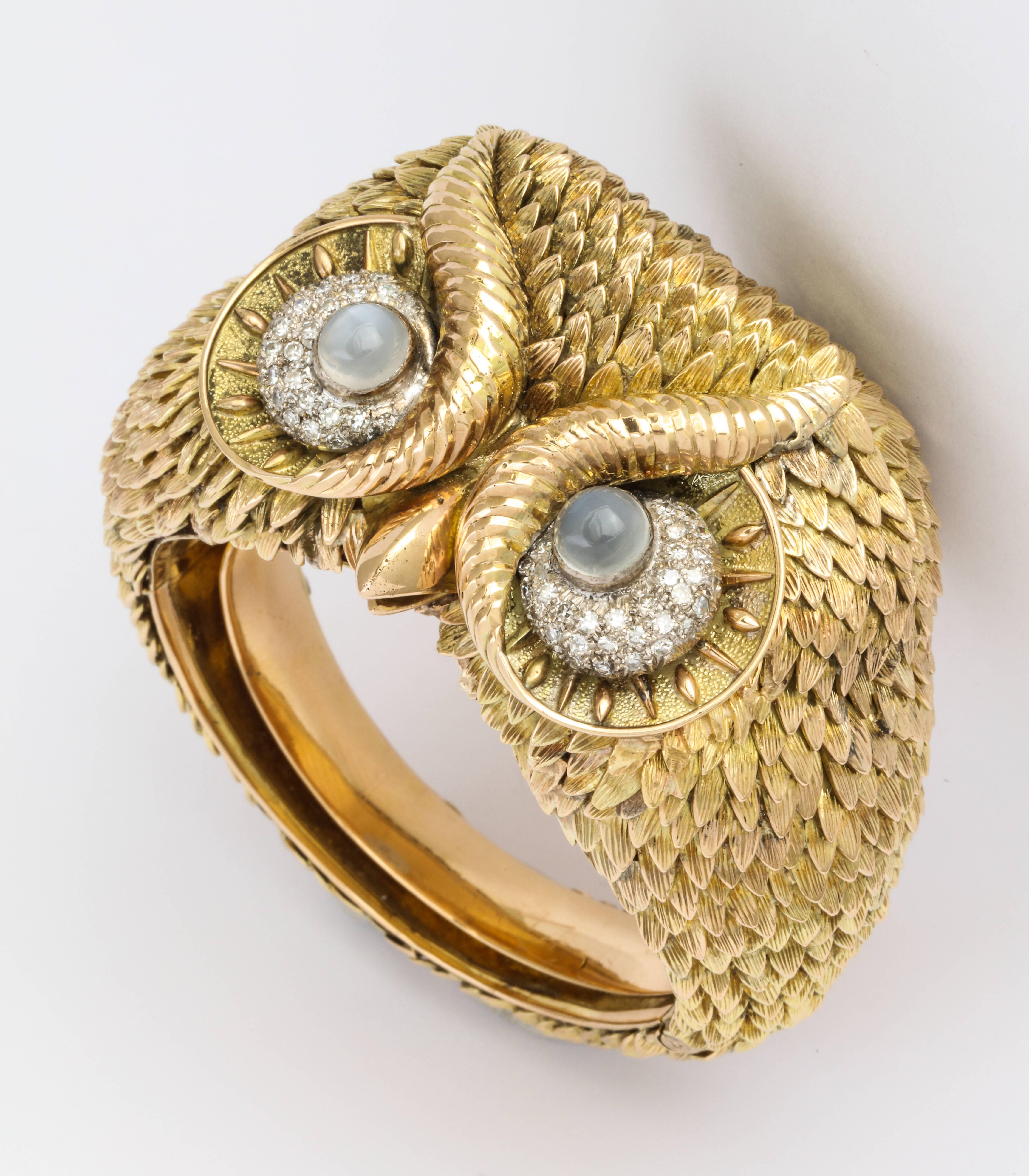 Made to order in the 1960s this exceptional figural owl bracelet is completely hand crafted of 14K gold with each feather individually formed and applied in curved layers forming a sculpture for the wrist set with star moonstone eyes  surrounded by