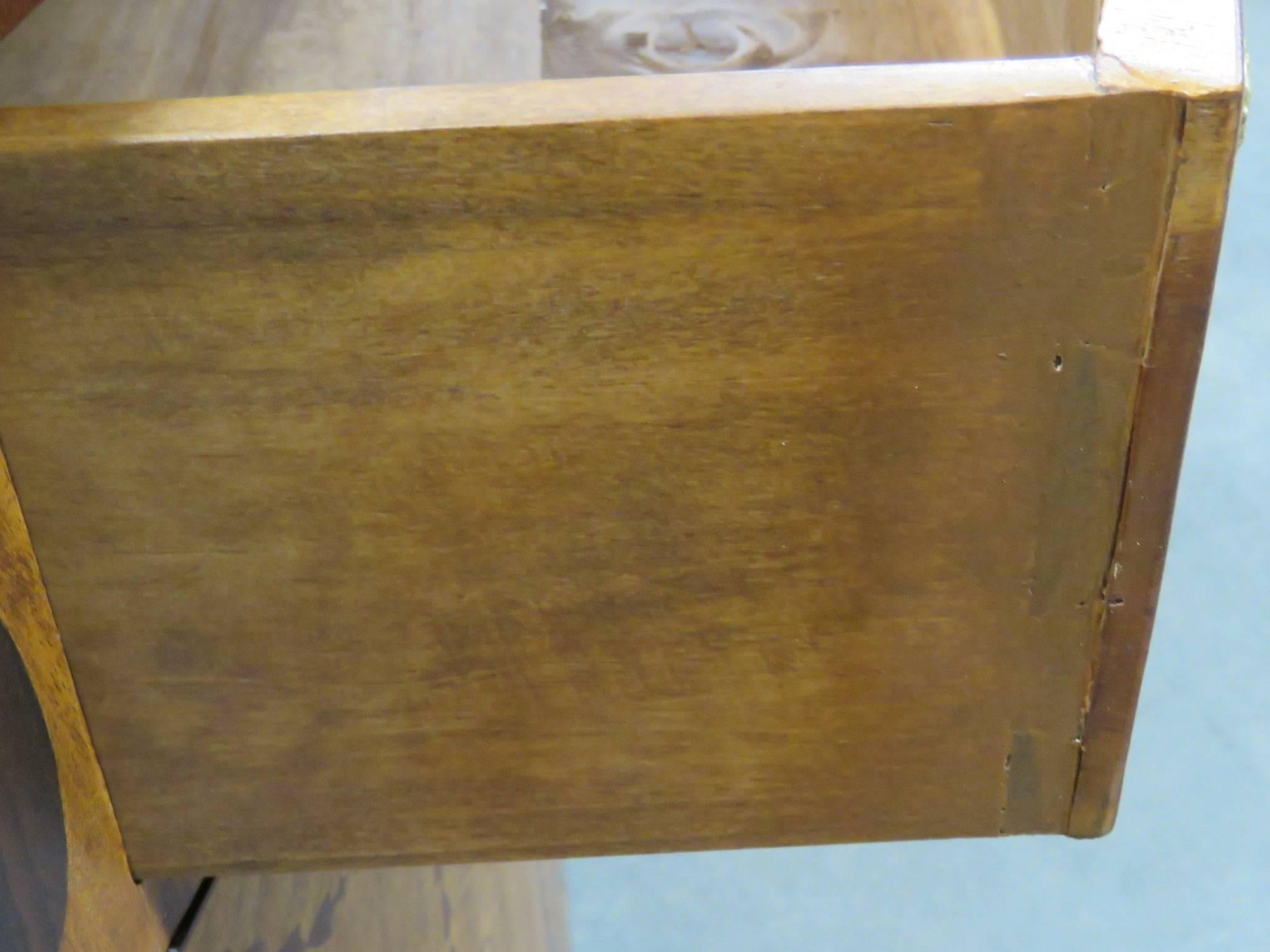 Commode has inlaid floral designs and urns.