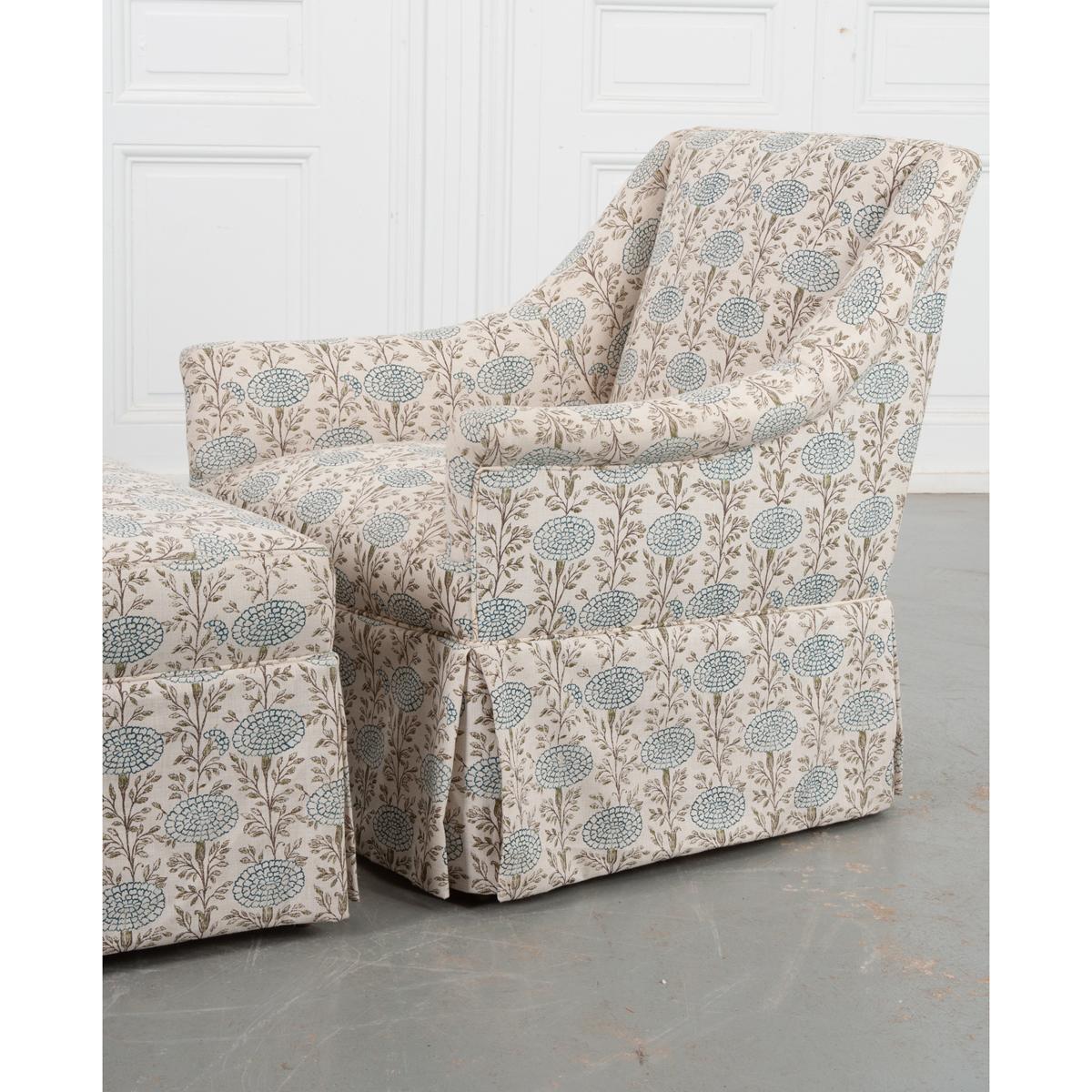 A charming armchair and ottoman duo in matching Lisa Fine fabric. Custom made by Cisco, this petite set provides a comfortable and stylish place to relax without taking up too much space. The repeating blue flower pattern and cream base of the