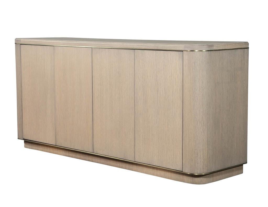 Custom made cerused oak brass sideboard buffet. Carrocel custom made sideboard, made of ceruse oak with a grey wash finish, with a rich burnished brass detail surround, this sideboard has clean flowing curves accentuating it’s sleek modern style and