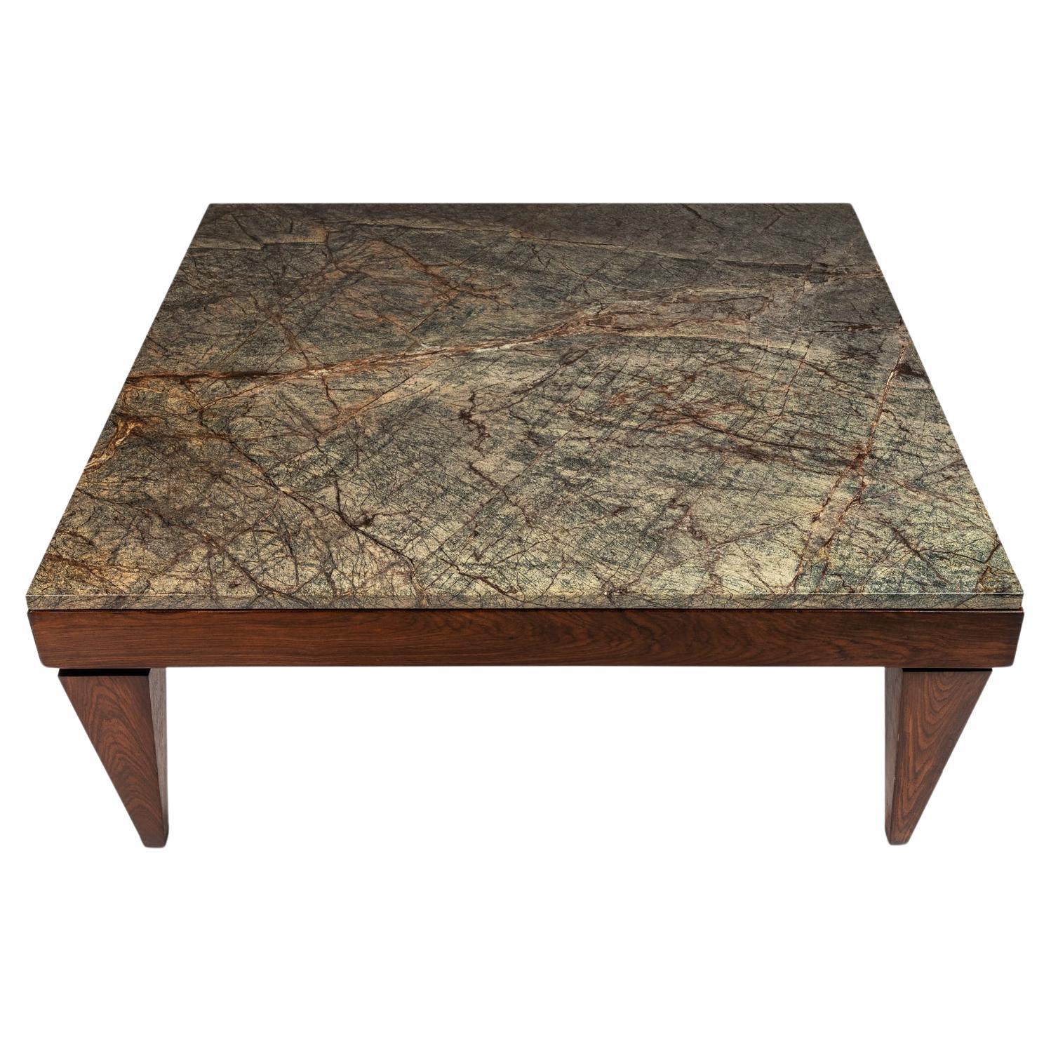 Voici une table basse sur mesure, unique en son genre, conçue d'après le style de Gio Ponti et dont le plateau est constitué d'une plaque de granit massif poli. Les pieds sculptés de manière complexe dans des dalles d'acajou massif confèrent à cette