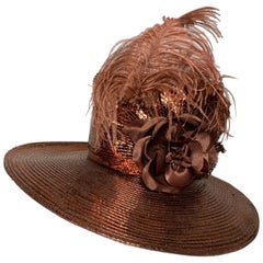 Cappello a tesa media in paglia di rame su misura con corona alta di piume e fiori di seta
