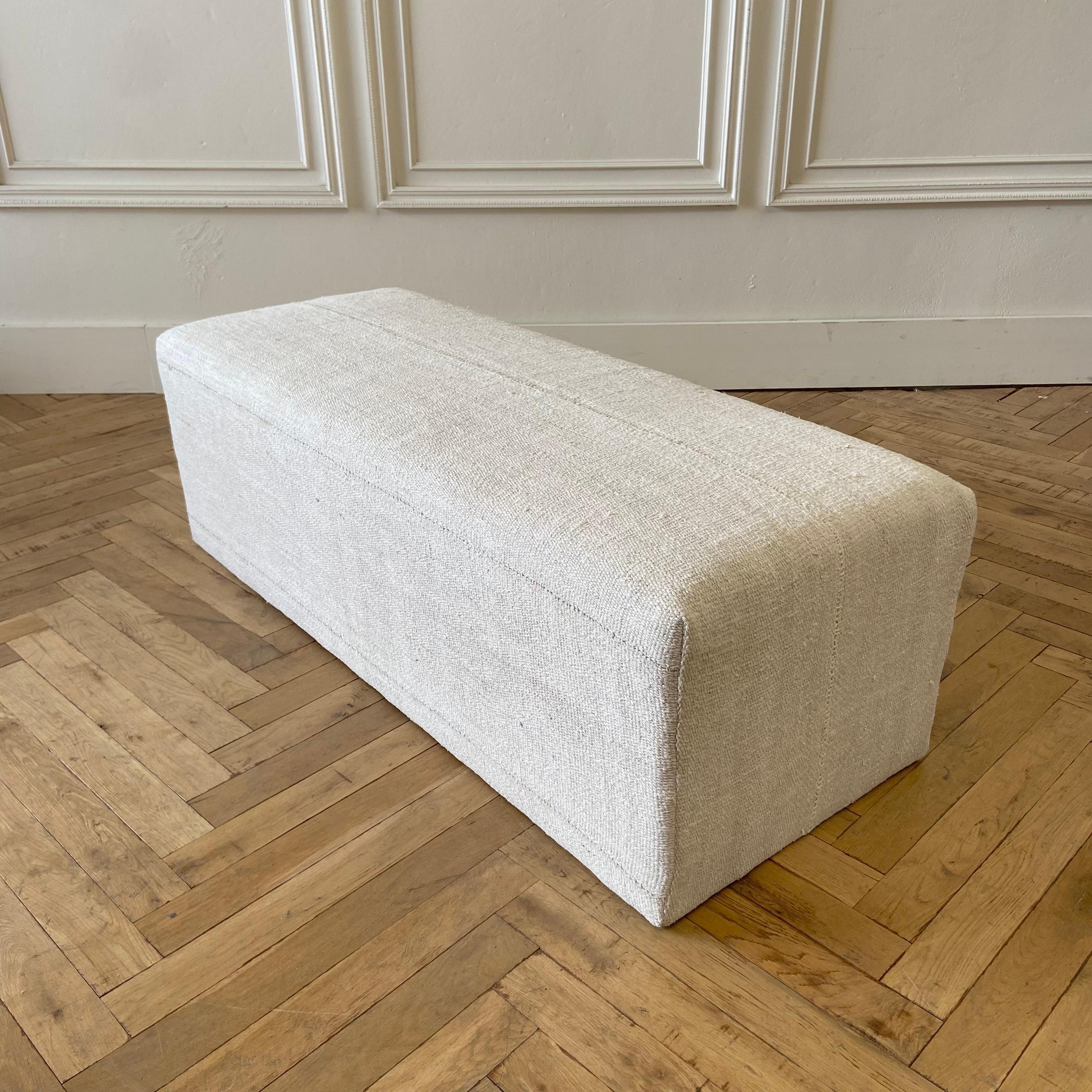 Beautiful Custom Made Cube ottoman 
Size: 53”W X 20”D X 18”H
Made from a vintage turkish hemp and wool rug, in an off white, with original beautiful hand tied stitched center seam.
Original seams, sewn with an overlock under to prevent any