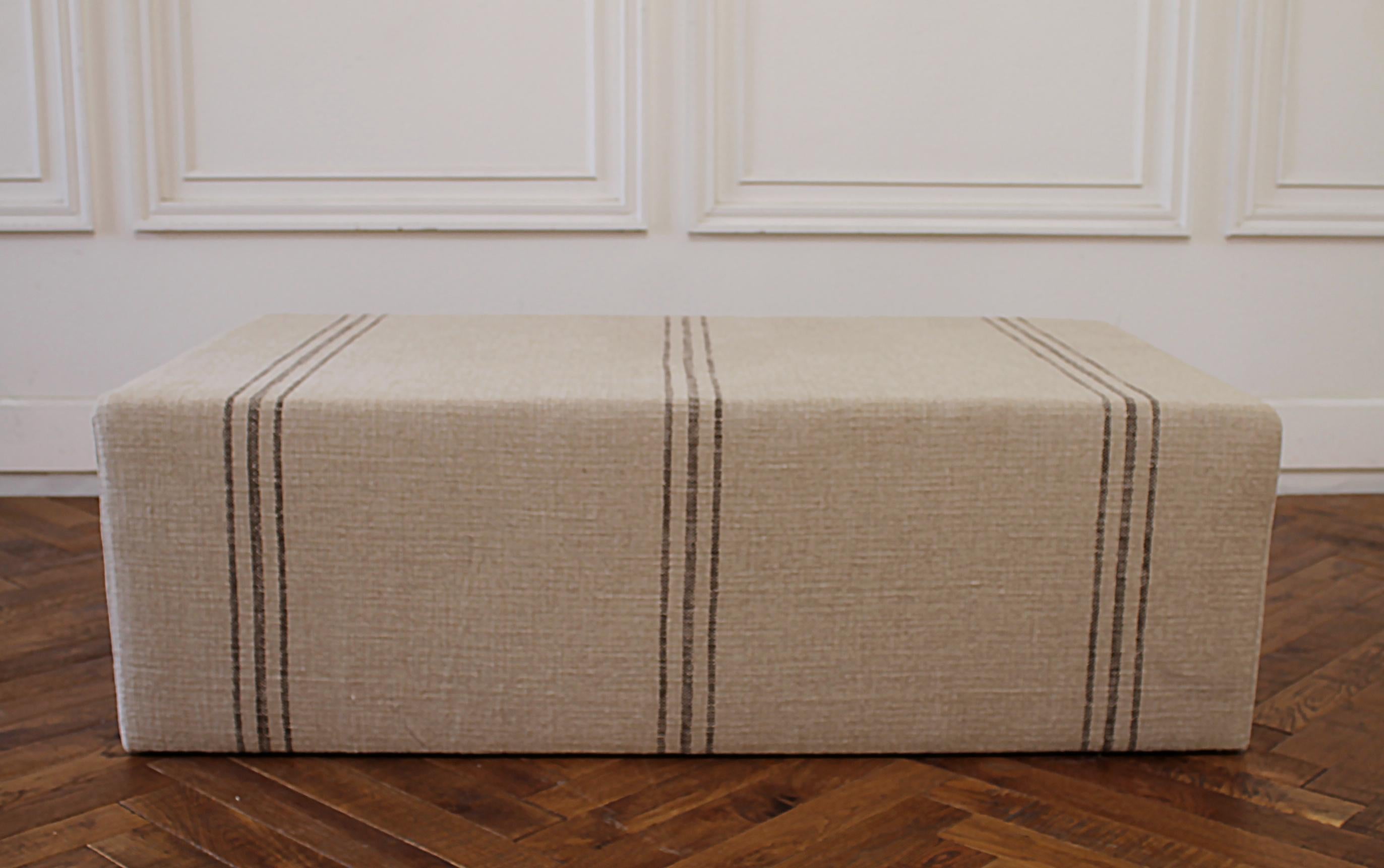 Custom made Cube ottoman with Schumacher Tortola 62841 Marine. upholstery made by full bloom cottage this cube ottoman is perfect for use as a coffee table or end of the bed. The fabric is a heavy thick linen with a dark brown color stripe.
