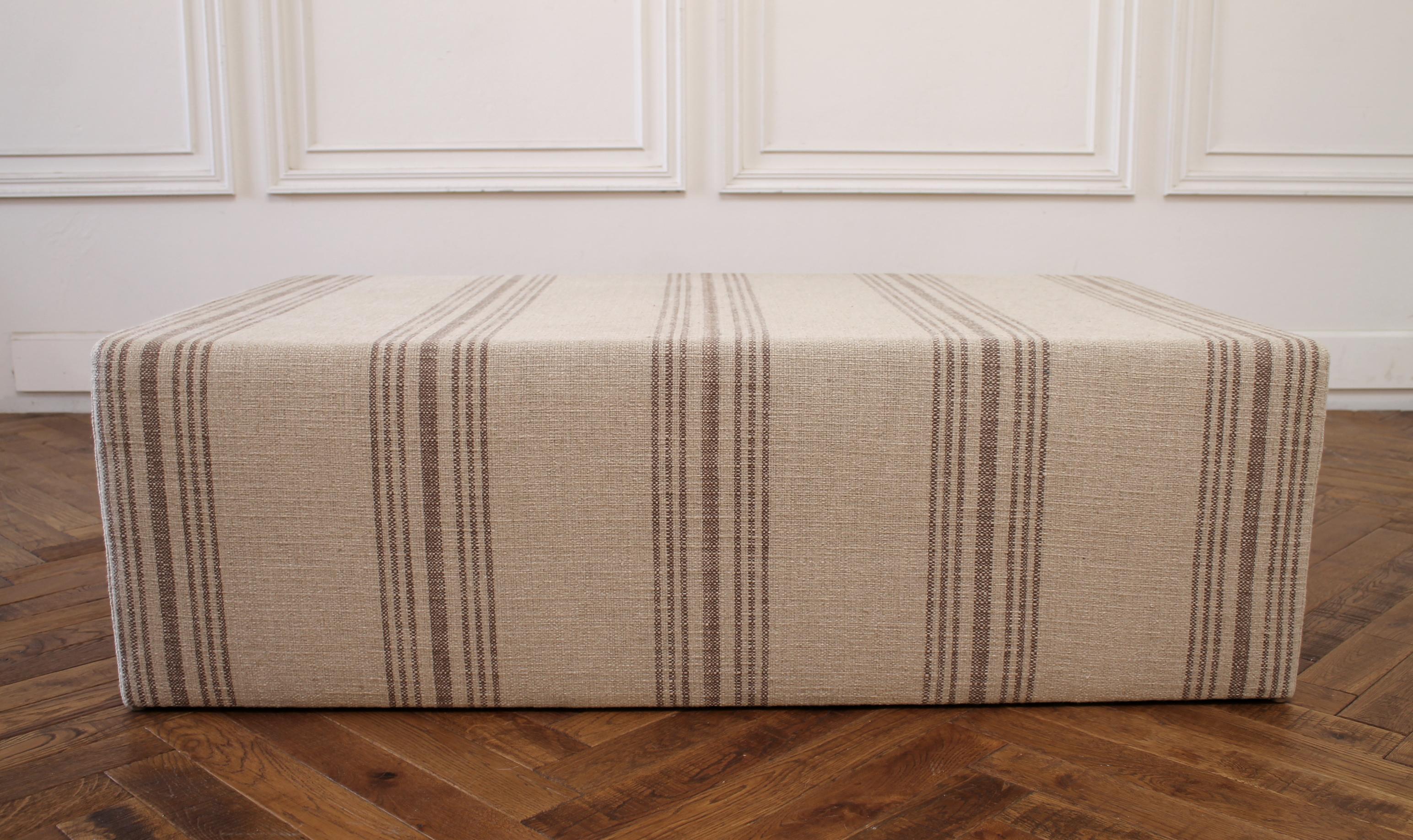 Custom made cube ottoman with natural Grainsack style upholstery made by Full Bloom Cottage this cube ottoman is perfect for use as a coffee table or end of the bed. The fabric is a heavy thick linen with a dark brown multi stripe.
Measures: 51