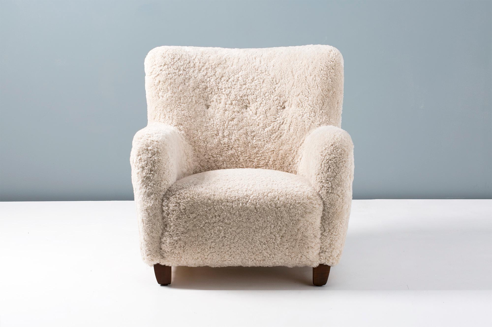 Sheepskin Armchair originally designed by Danish architect Jens Houmoller Klemmensen in 1939. 

This high-end reproduction is handmade to order at our workshops in England under license from the Klemmensen estate. The chair legs are available in
