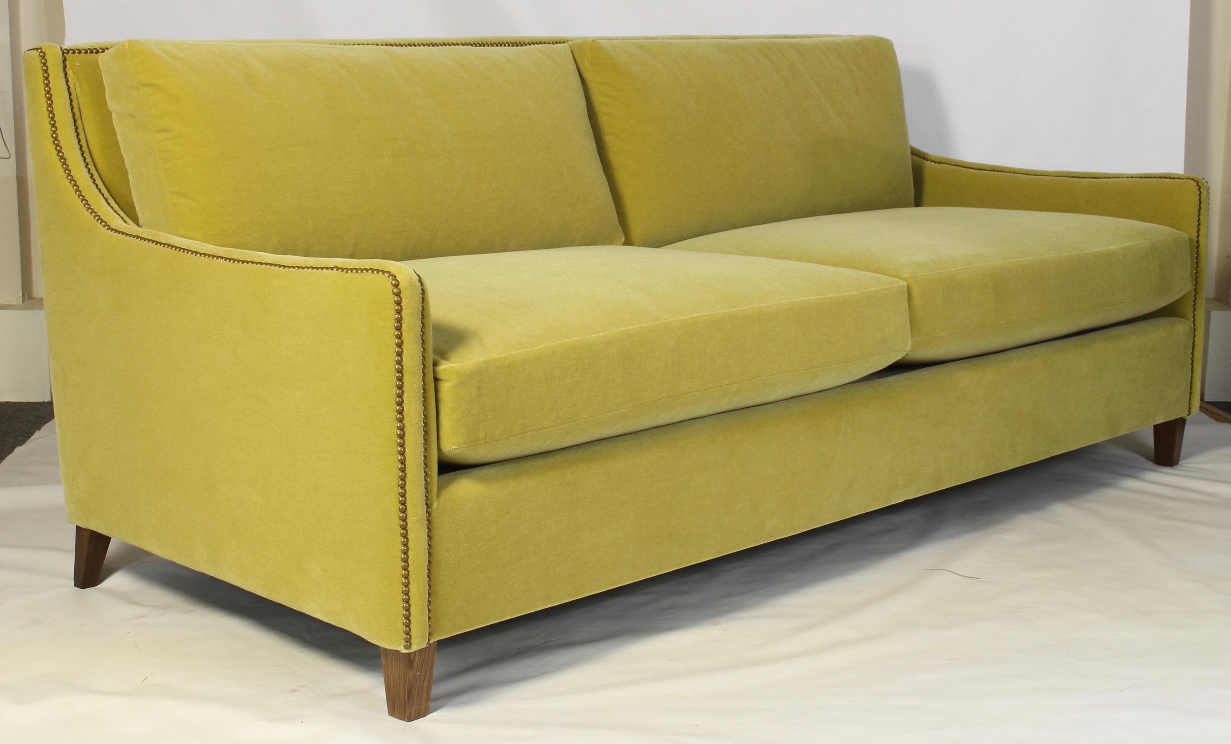 A Classic yet contemporary custom designed deep-seated sofa covered in an S. Harris citron green wool mohair fabric accented with brass tacks.