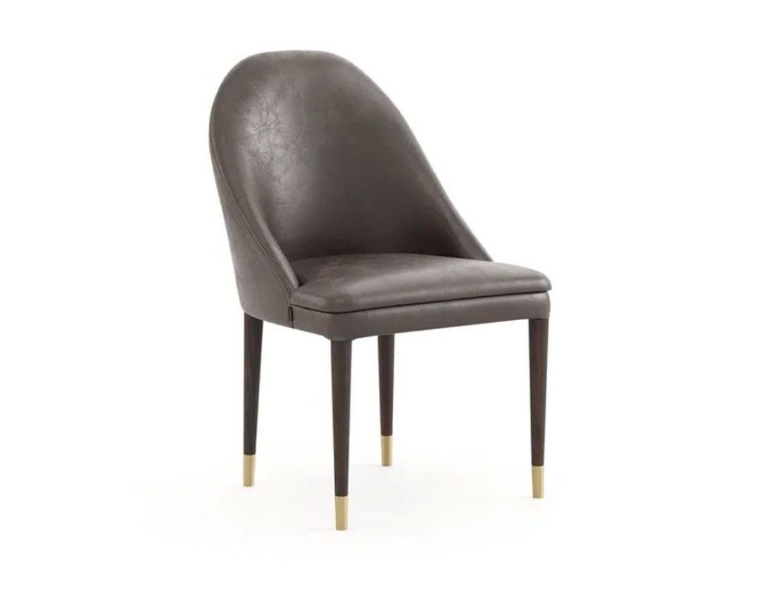 Voici cette exquise chaise design sur mesure qui allie luxe et fonctionnalité. Cette élégante chaise présente une silhouette élégante et des lignes épurées, revêtue de cuir avec une variété de choix de couleurs. Le cadre est en bois massif. La