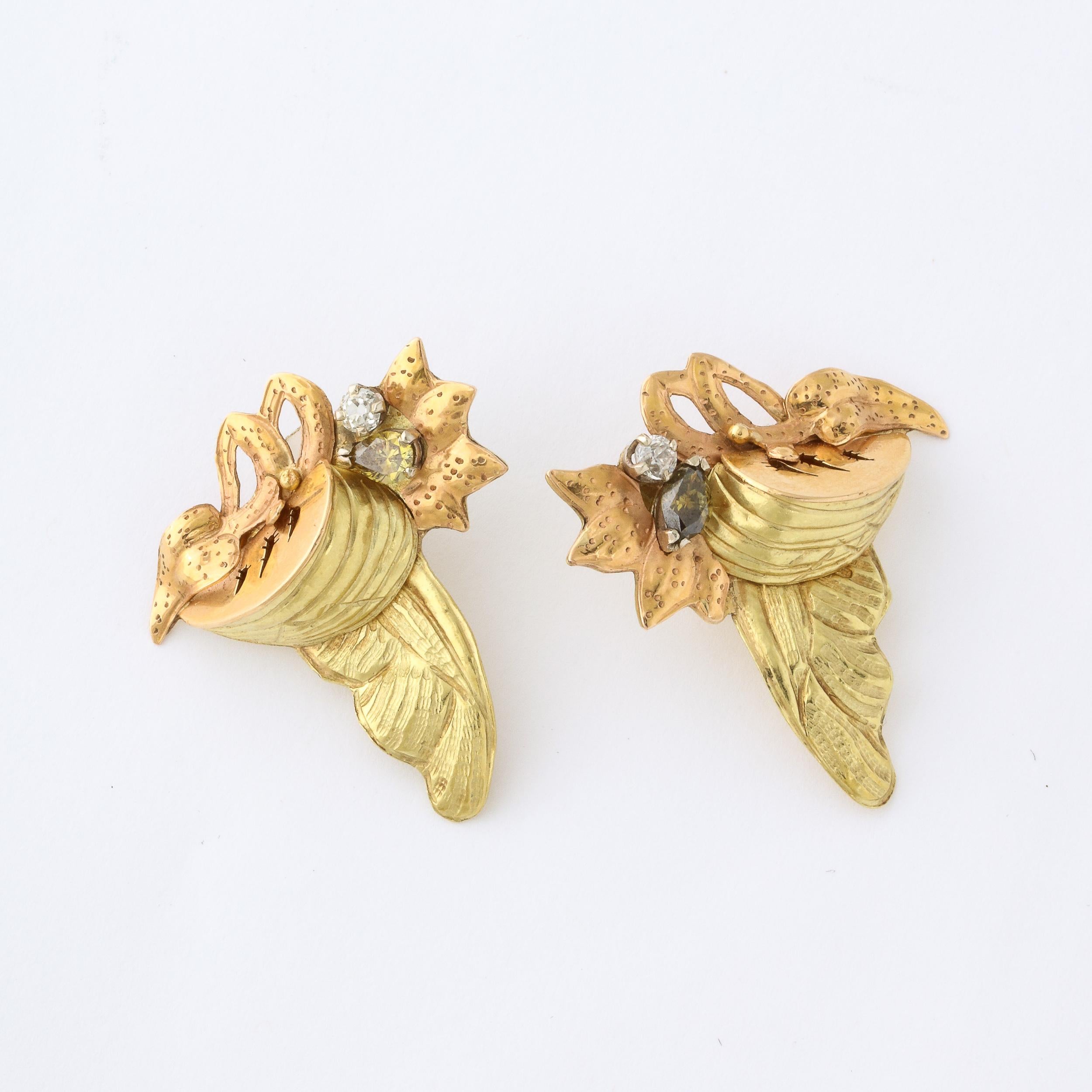 'These retro style pierced earrings were custom made by Barnaby circa 1980. They are made of 18k rose and yellow gold in a stylized floral and geometric design. Each earring is set with a round brilliant cut diamonds and each earring is also set