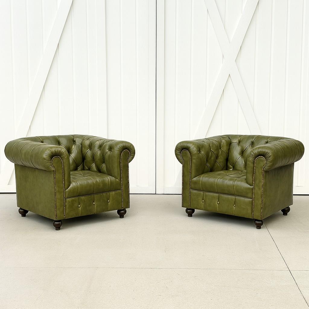 Cette belle paire de chaises Chesterfield fabriquées en Angleterre présente l'élégance intemporelle et la durabilité qui ont fait de ce design un classique depuis des siècles. Recouverts de cuir vert riche, les fauteuils présentent le dossier