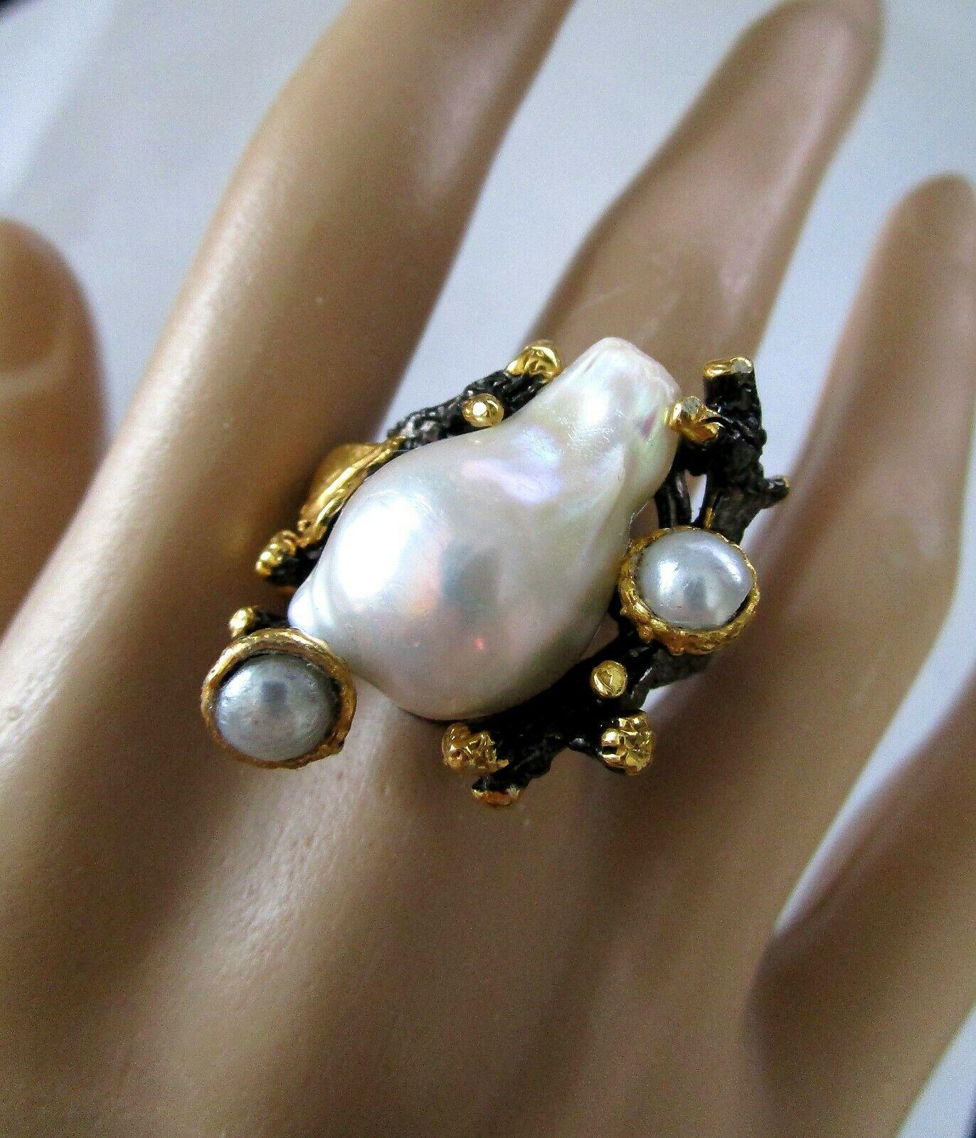Ourstanding Abstract Artisan Ring, Hand crafted in Oxidized Sterling Silver with 18K Gold plated stylized leaves and branches. Center Hand set with a large Baroque Genuine Pearl and accent Pearls in surround. Marked: 925. Size 8. Sure to be admired