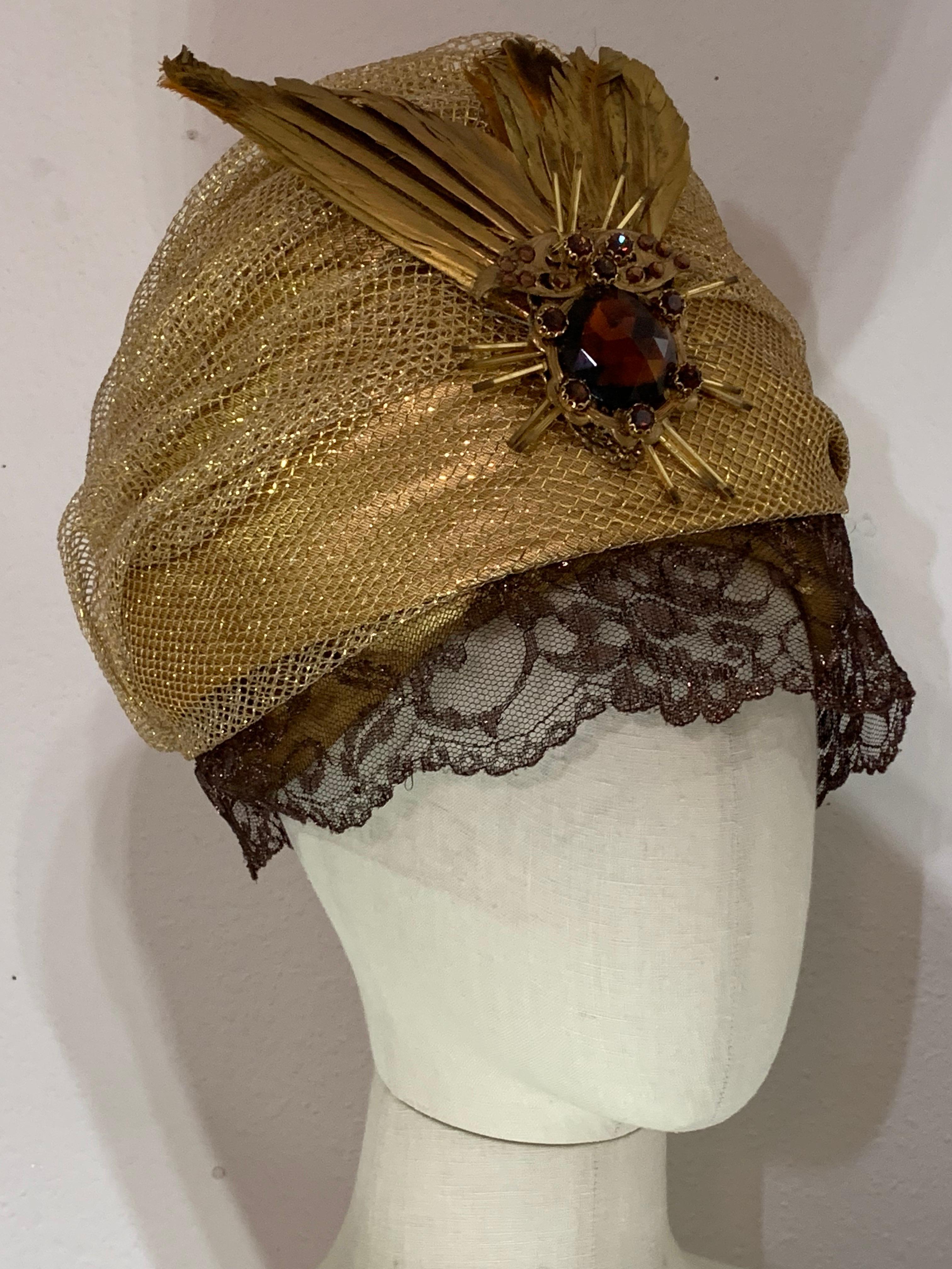 Turbante su misura in rete e lamé oro con velo in pizzo bronzo e spilla di piume dipinte: Un favoloso turbante realizzato da Suzanne Couture Millinery con un velo corto in pizzo lamé e ali di uccello dipinte d'oro con un'insolita spilla in vetro