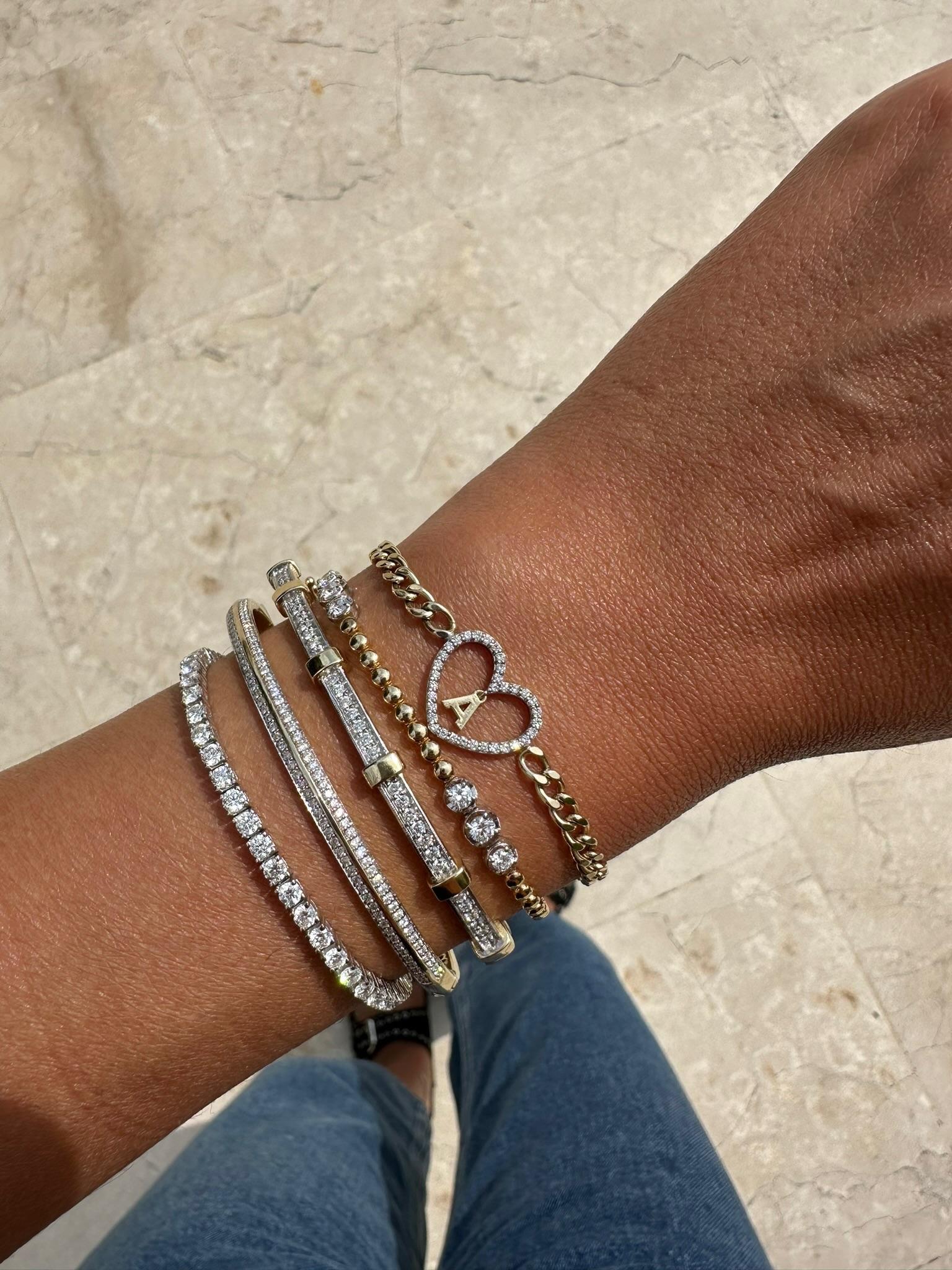 Célébrez votre individualité avec ce bracelet sur mesure, dont le centre est constitué d'un cœur en diamant pavé étincelant, qui abrite délicatement une breloque initiale personnalisée. Réalisée en or jaune étincelant et dotée d'une chaîne