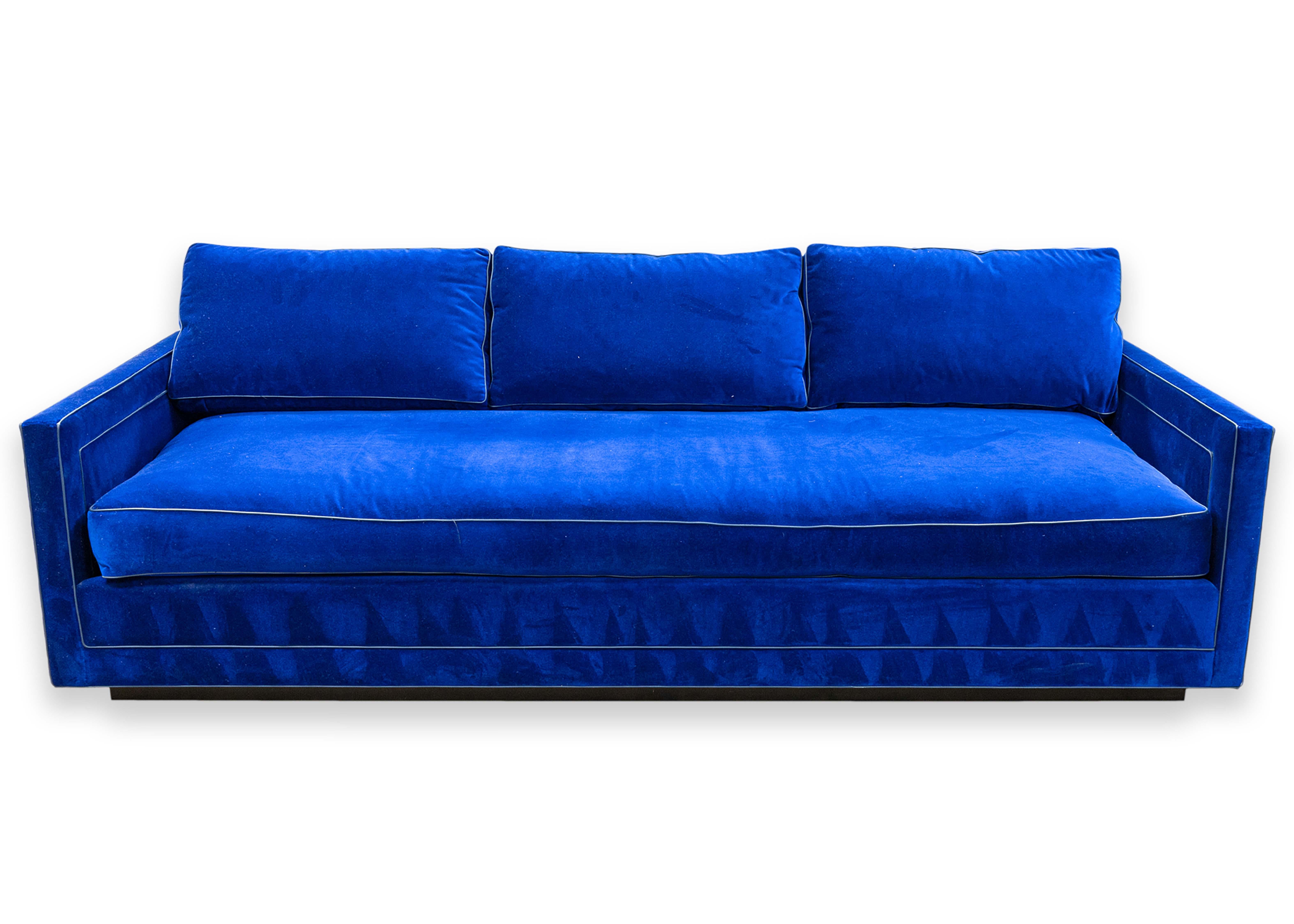 Un canapé moderne contemporain en velours bleu. Ce canapé spectaculaire présente un design simple mais magnifique. Il est conçu d'une seule pièce, avec une fine base noire. Ce canapé comporte trois coussins de dossier et un coussin d'assise massif
