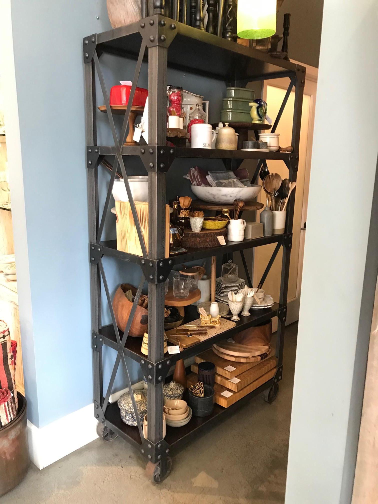Custom made Industrial iron and walnut free standing shelving unit. The frame is heavy iron with rivets and cross bars on iron wheels and 5 espresso stained walnut wood shelves. 

A handsome addition to your kitchen, living room or study!
  