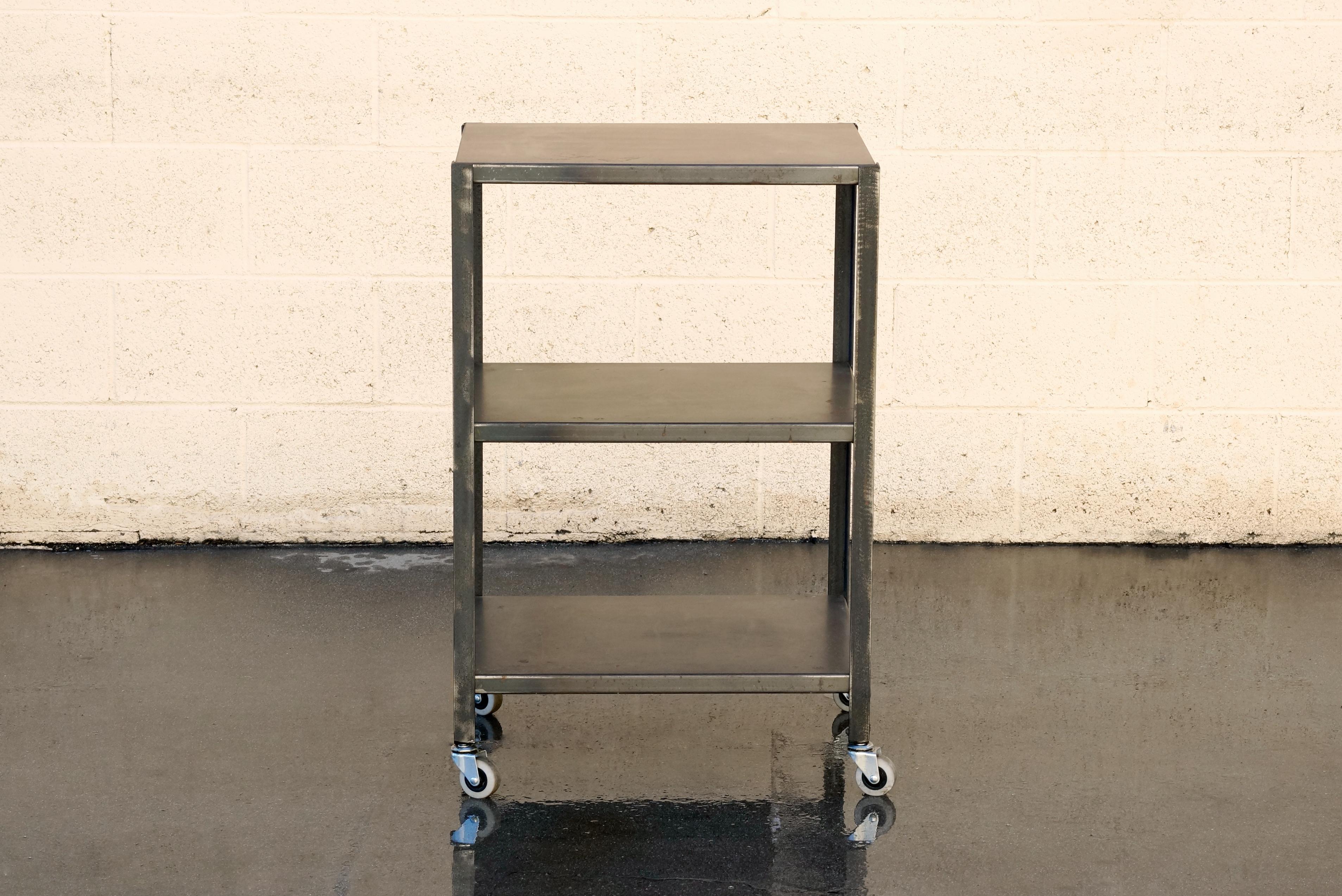 Our custom made three-tier steel rolling cart is a versatile piece perfectly suited in an office, workshop or for retail display. Quality made to order in our Los Angeles shop. Designed with a lovely variegated patina, lightly clear-coated. Can be