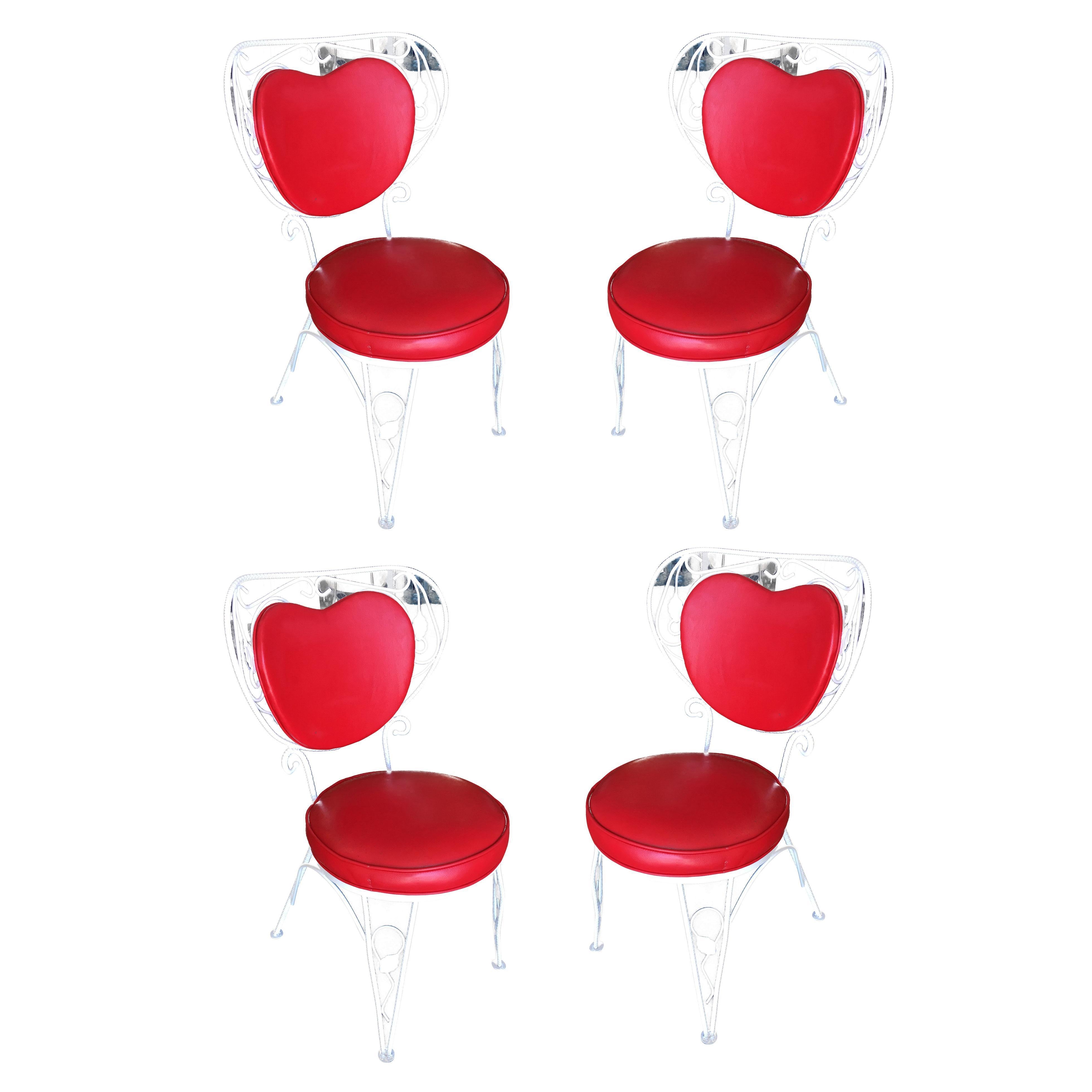 A set of four custom-made rod iron and steel rebar patio chairs with distinct scrolling red heart backrest. They are in excellent condition. 

Dimensions: 
34.5