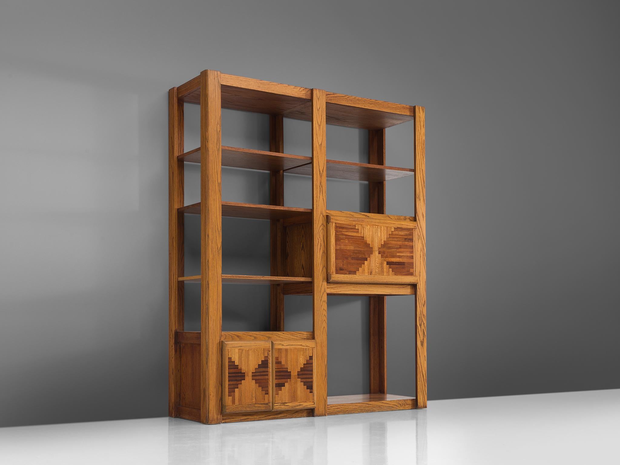 Bookshelf, oak, Italy, 1950s

This grand custom-made open shelf was made in the 1950s. The design of this original cabinet shows two cabinets with inlayed doors. Two columns feature multiple shelves. The bottom cabinet has two doors and the top