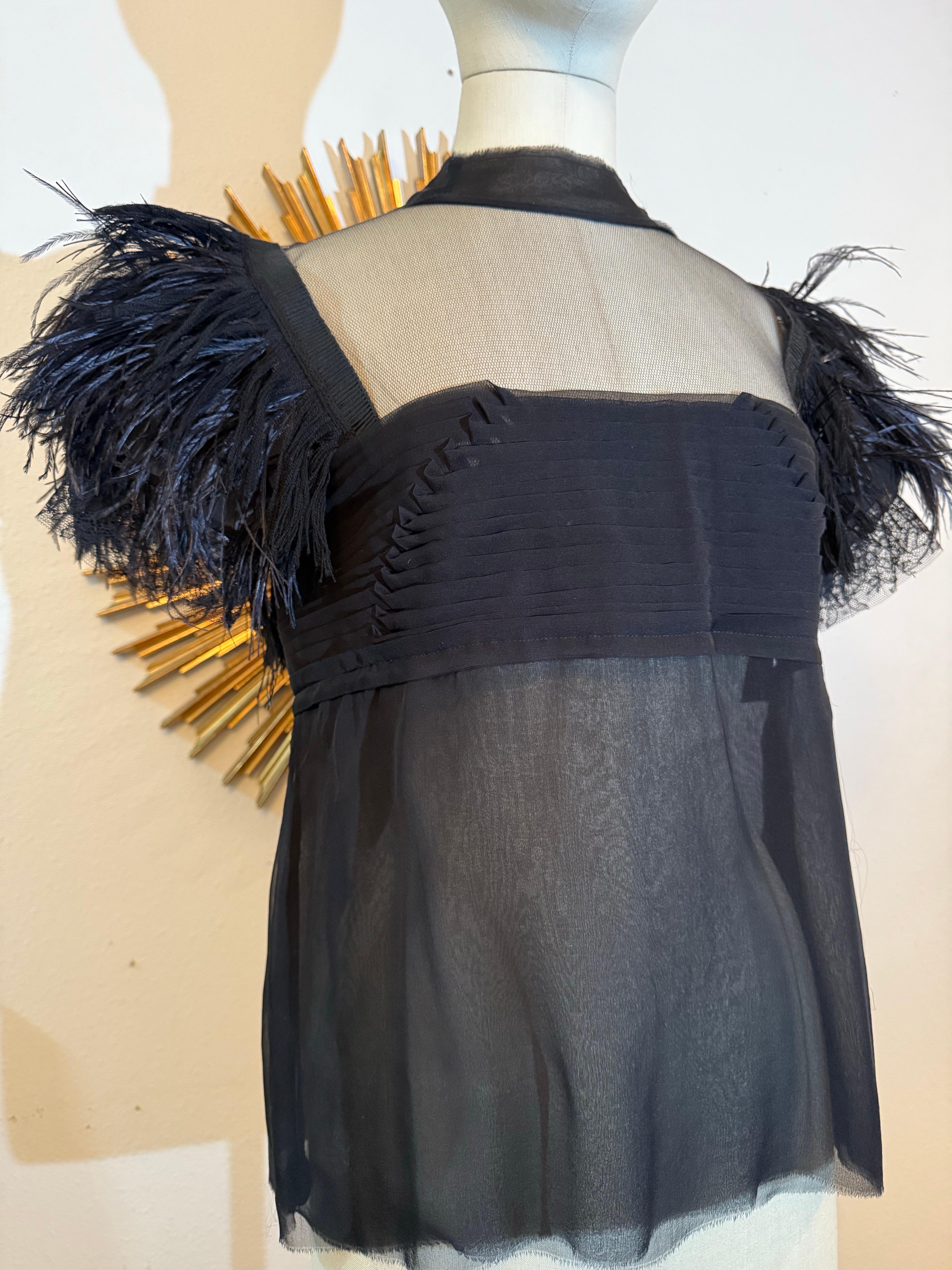 Camicetta su misura in chiffon di seta e tulle nero plissettato con maniche di piume: Trattamento del décolleté di ispirazione vittoriana in raffinata rete di seta, con busto in chiffon di seta plissettato e frange in piume di struzzo e rayon a