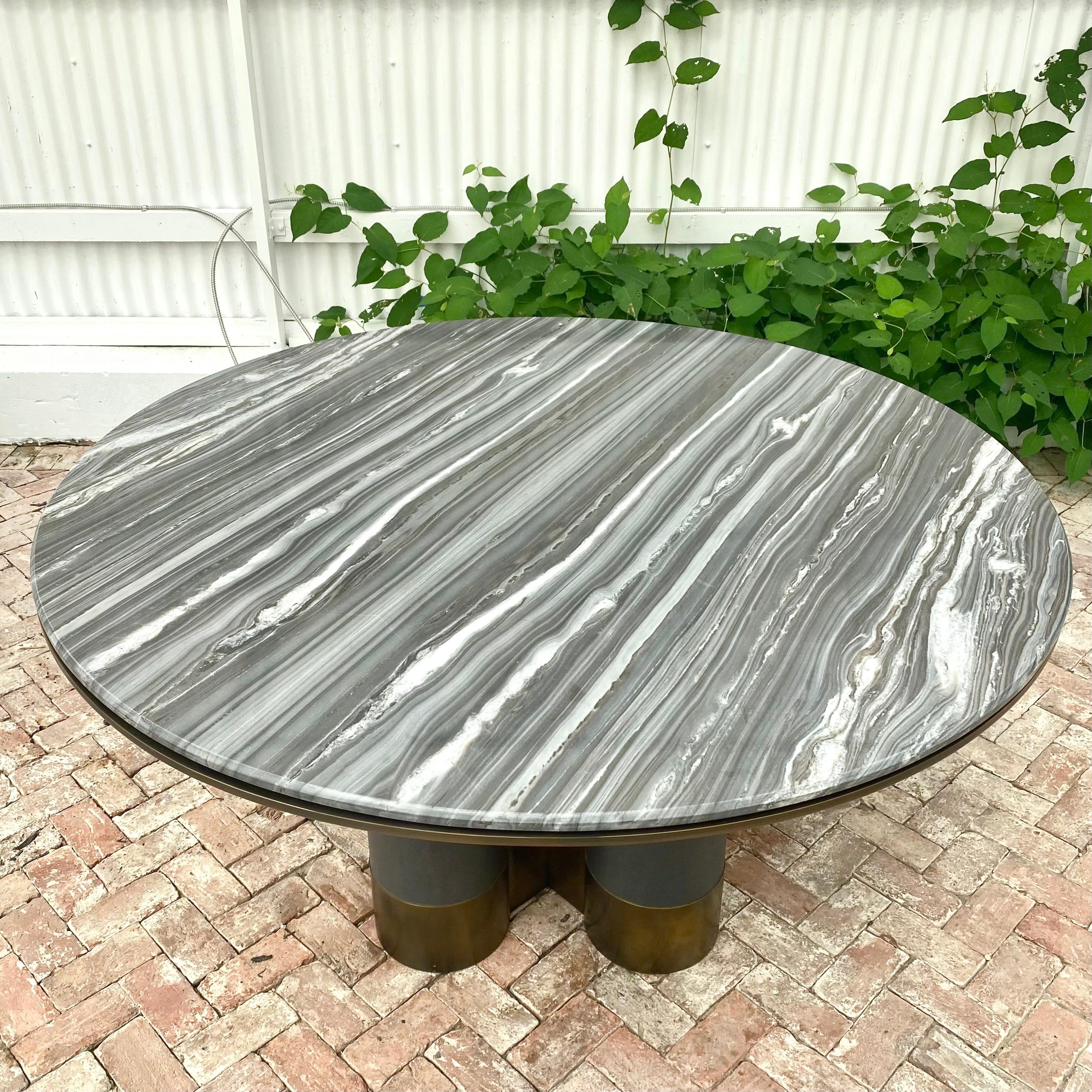 Large round marble dining table custom made for a client that needed to downsize to a smaller table. Palisandro Bluette marble polished top with gorgeous white streaking throughout. Has four cylindrical steel legs wrapped in dark grey leather and