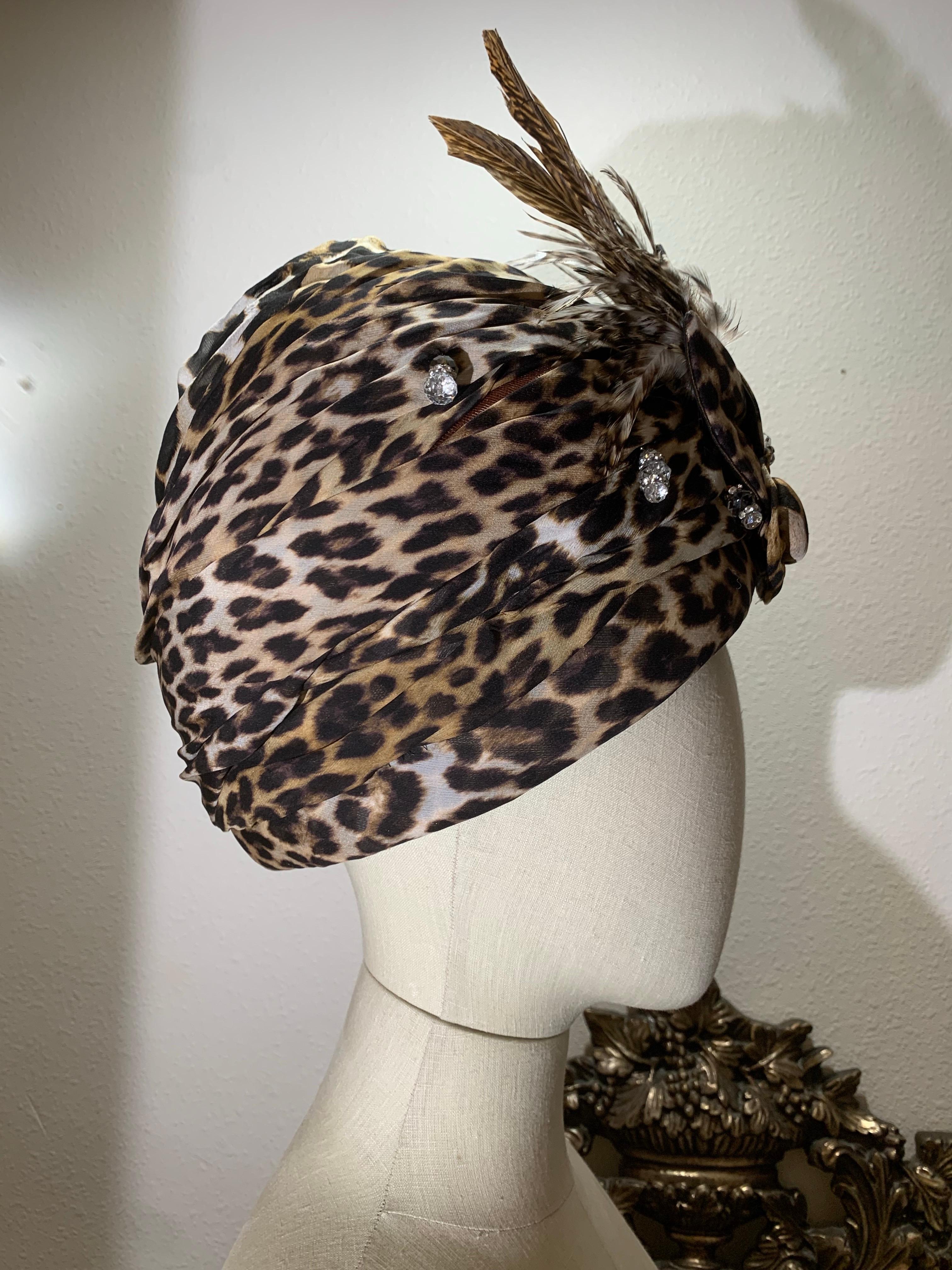 Turbante in chiffon di seta leopardato su misura con fiore e piume in tessuto abbinati: 
Creato da Suzanne Couture Millinery. Chiffon leopardato dalla forma audace, avvolto e drappeggiato su una base rigida per dare volume. Perline di cristallo