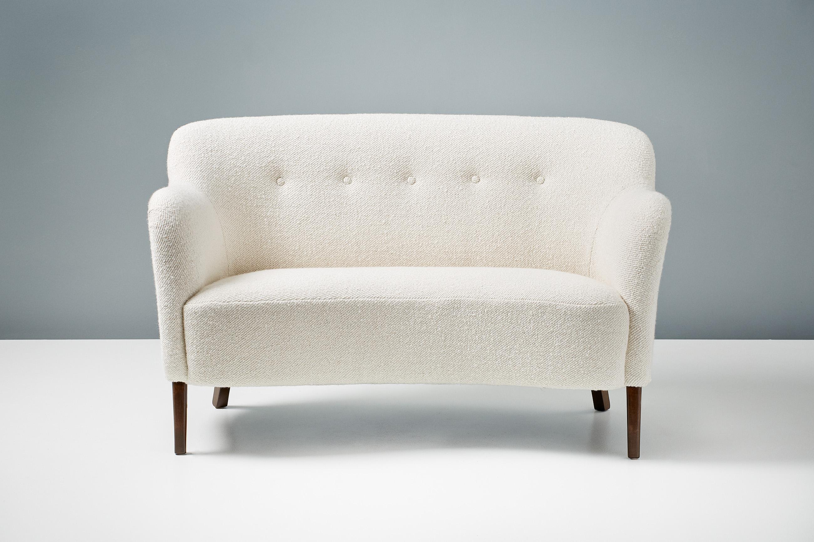 A custom-made new edition of this classic love-seat sofa by Danish designer and cabinetmaker: Alfred Kristensen. This re-edition is produced under license in Sweden by Dagmar and available to order in a range of upholstery and wood