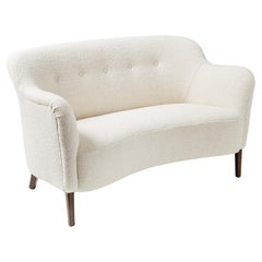 Sofá Love-Seat hecho a medida por Alfred Kristensen. Disponible en tapicería COM