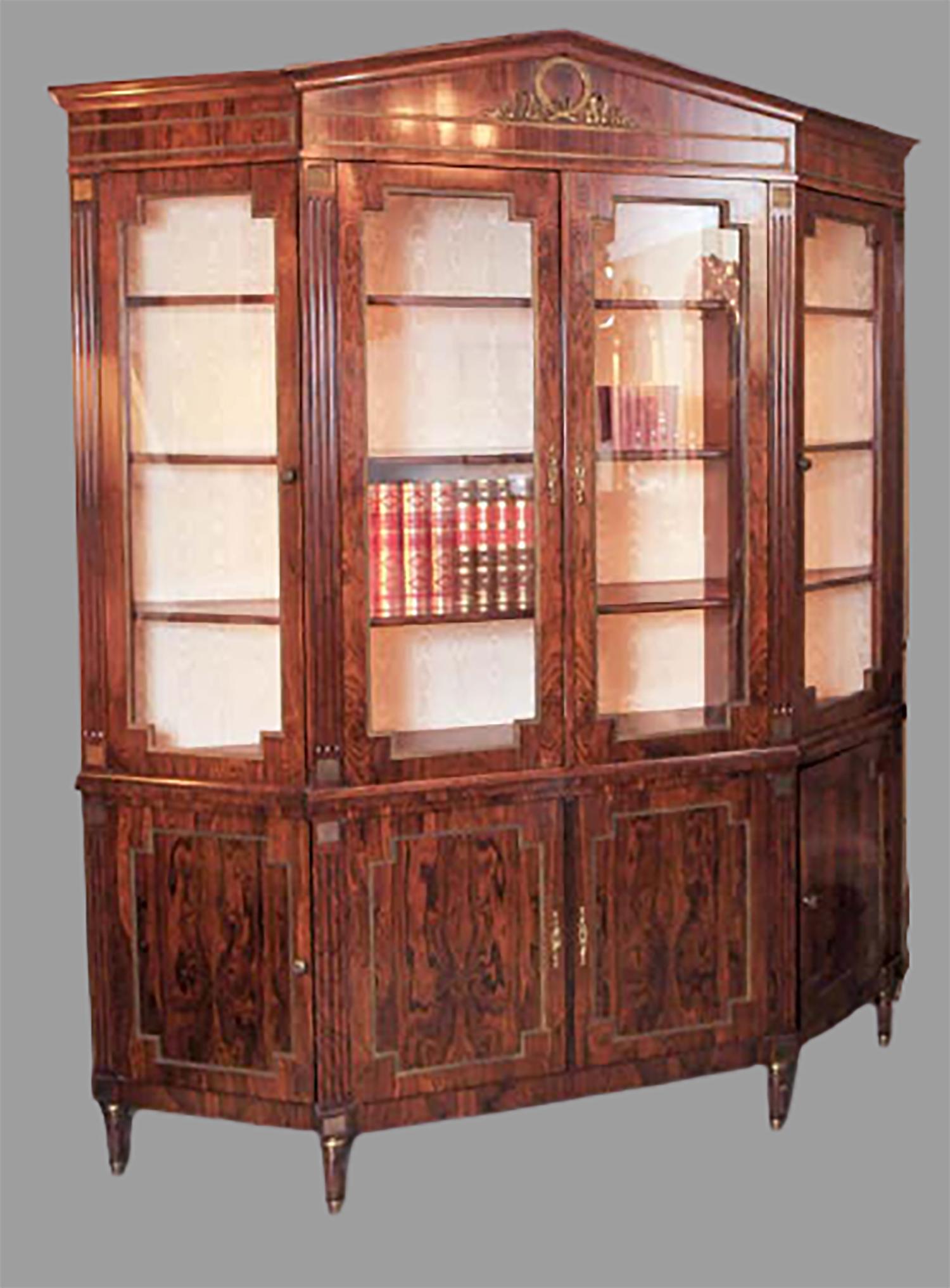 Finest rosewood and ormolu-mounted bookcase/breakfront with a beautifully carved ribbon-form medallion atop four glass doors with bronze trims, over four enclosed cabinet doors with fully finished interiors, standing on fluted legs and bronze feet.