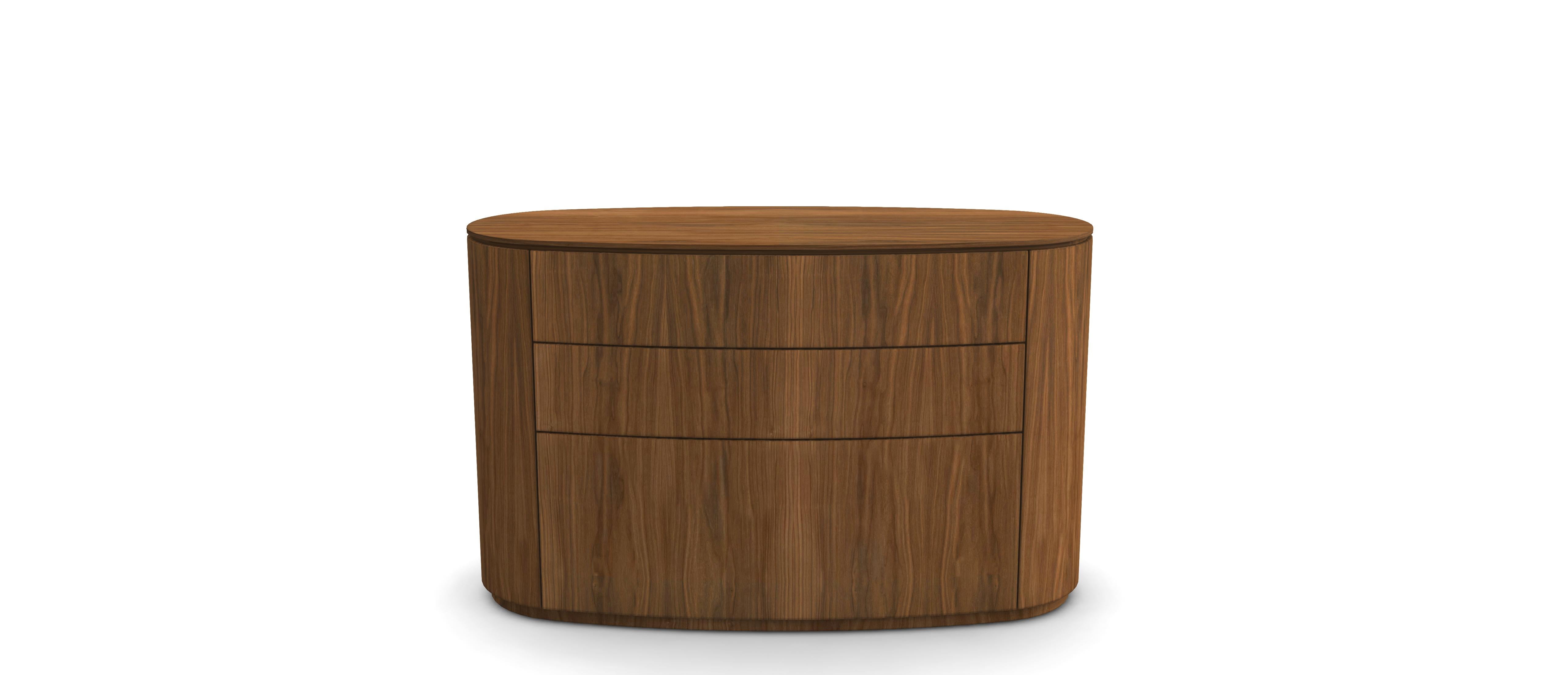 Une commode minimaliste et élégante, fabriquée en noyer massif (dessus et corps plaqué noyer), avec une silhouette ovale légèrement incurvée. Les façades des tiroirs sans joints conservent des lignes épurées avec de subtiles rainures horizontales,