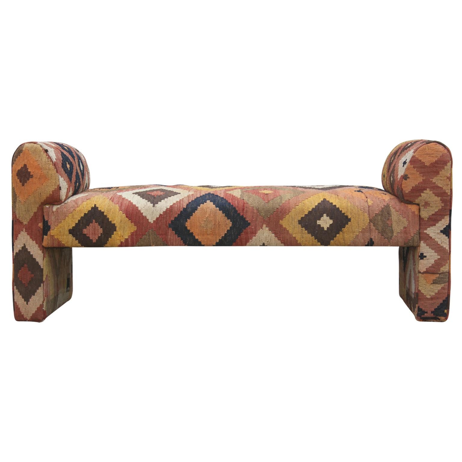 A custom Milo Baughman styled modern bench upholstered in a seventy year old whimsical geometric flat-weave tribal Kilim rug. Features warm amber and burnt orange tones. This piece will look great in any room, and the rug material will serve as a