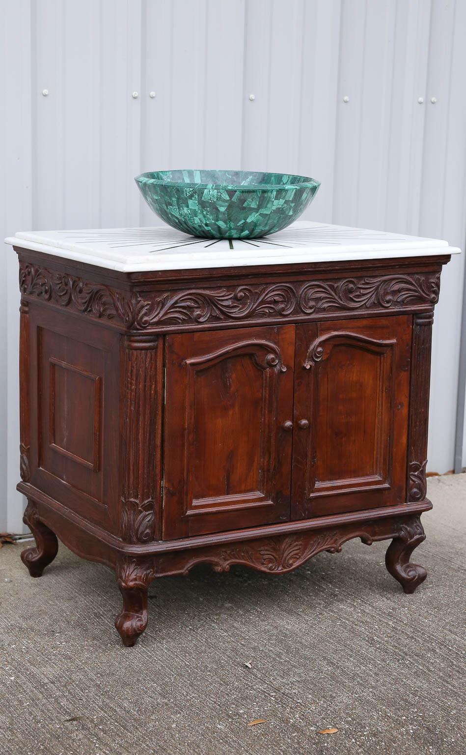 This unique vanity is part of wedding gifts given by a rich family in the west coast of Gujerat during elaborate marriage ceremony. The counter top is a fine white marble inlaid with brass. It sits on top of a handcrafted and carved teak wood