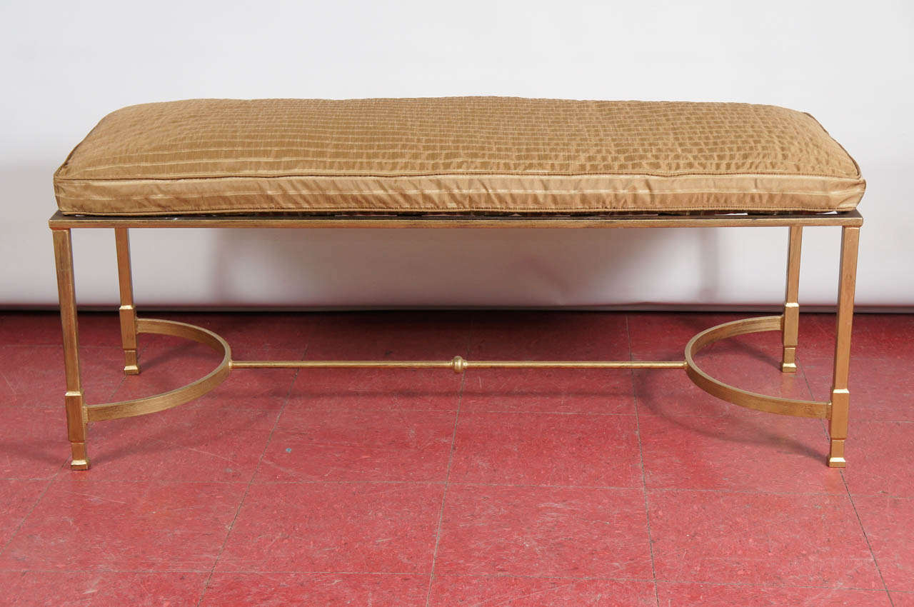 This neoclassical style metal bench or stool with two curves and stretcher in between can be used for various seating purposes or at the foot of a bed. The base topped with a piece of glass, stone or wood can serve as a coffee table. Cushion can be
