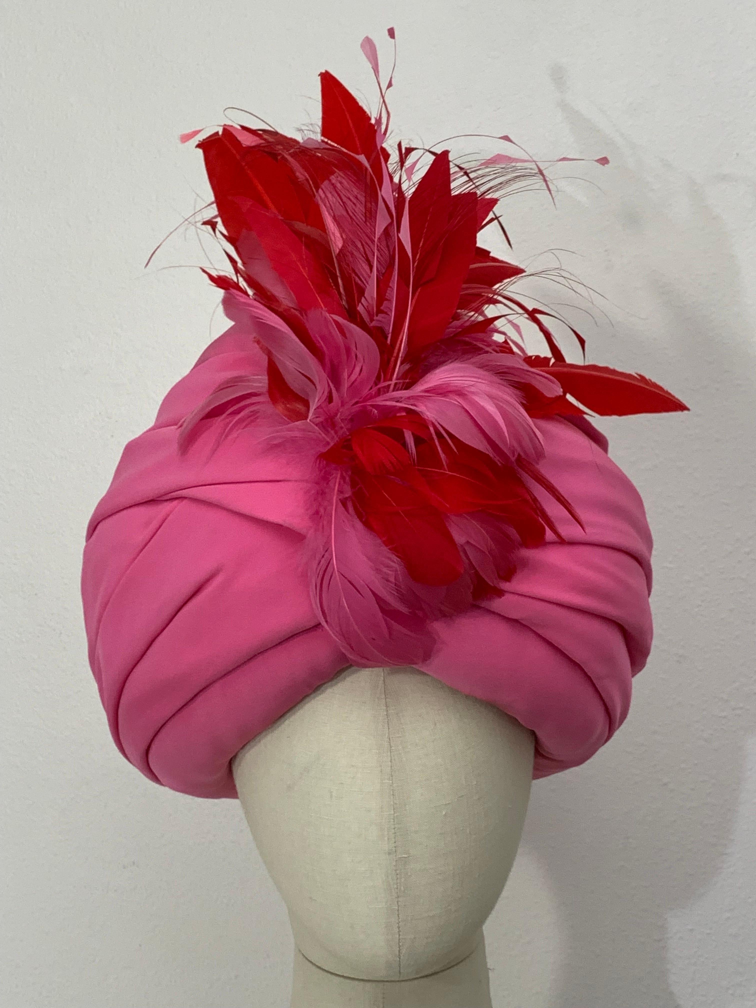 Turbante su misura in crepe di seta rosa con piume rosse e rosa sul davanti: Creato da Suzanne Couture Millinery. Rosa peonia in una forma audace, avvolto e drappeggiato su una base rigida per dare volume. Piume di coq rosse e rosa sul davanti.