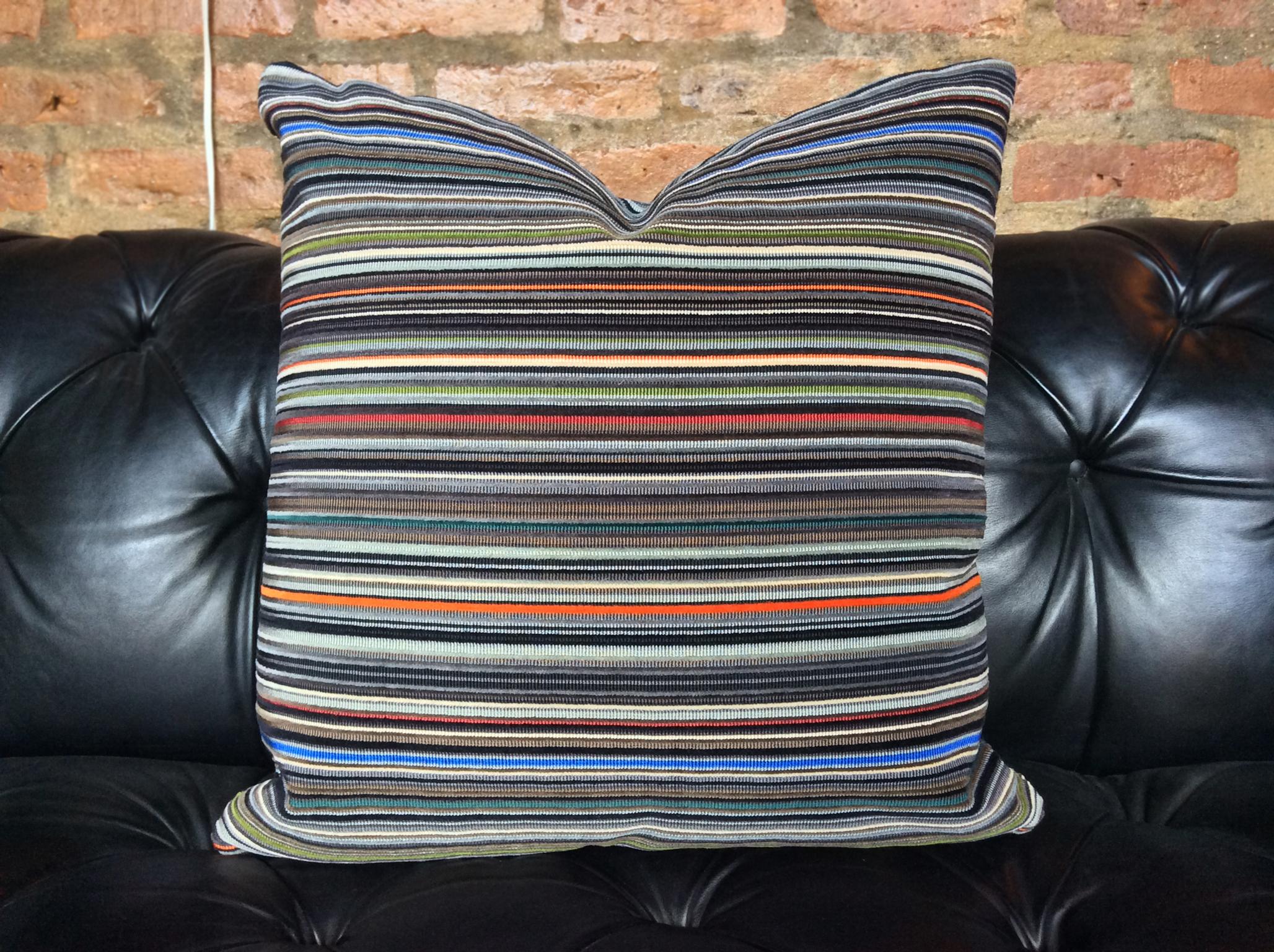 Handsomely designed pillow with Paul Smith textile. The fabric is a soft cotton, while its stripe patterning is a rich, lovely palette of varying colors. Each pillow is cushioned in a combination of down and Dacron. It's a pillow of comfortable and