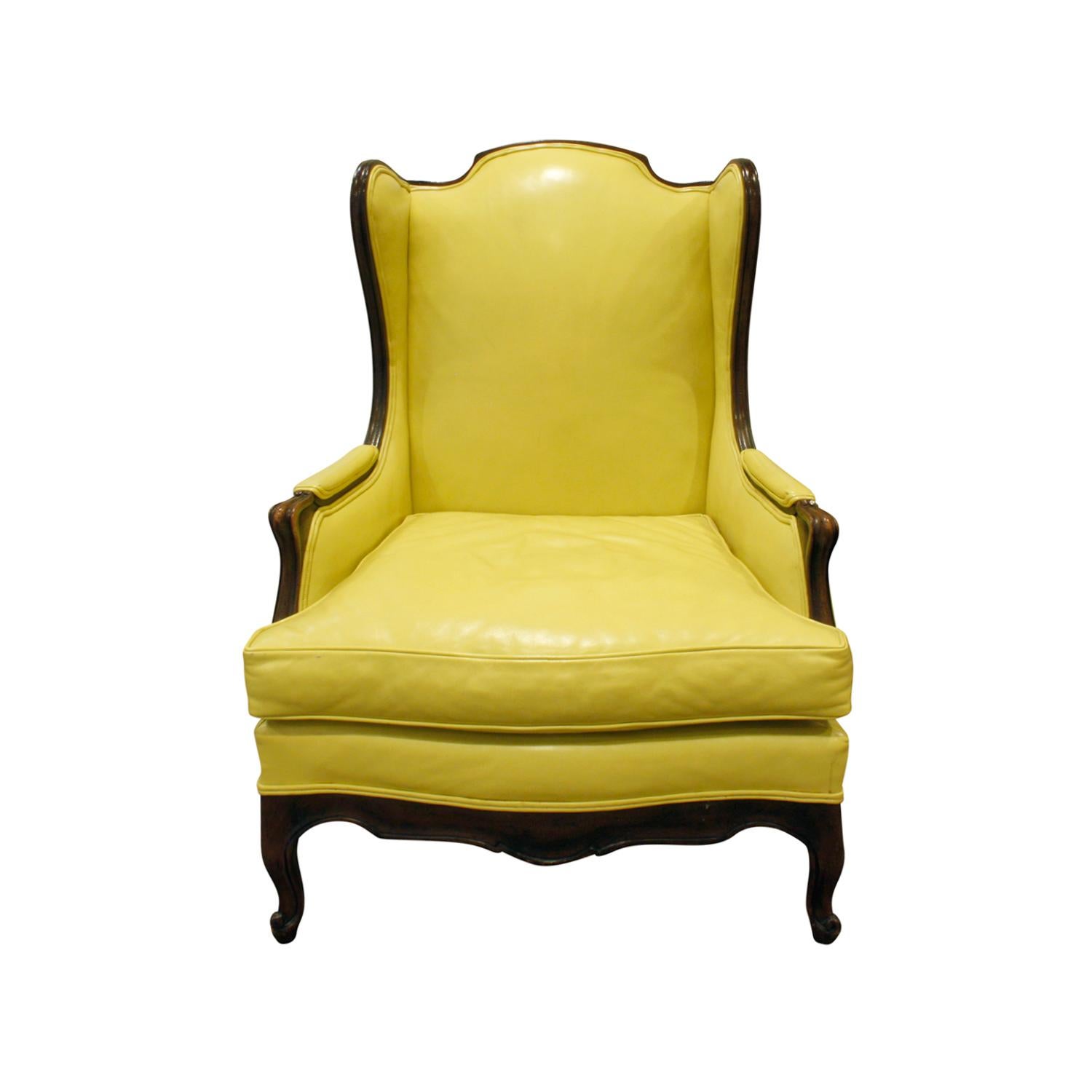 Regency style wing chair with carved arms and legs and original yellow faux leather upholstery by Mason-Art, American, 1950s (signed with original label “Mason-Art—Custom-Made” on the underside of the cushion).