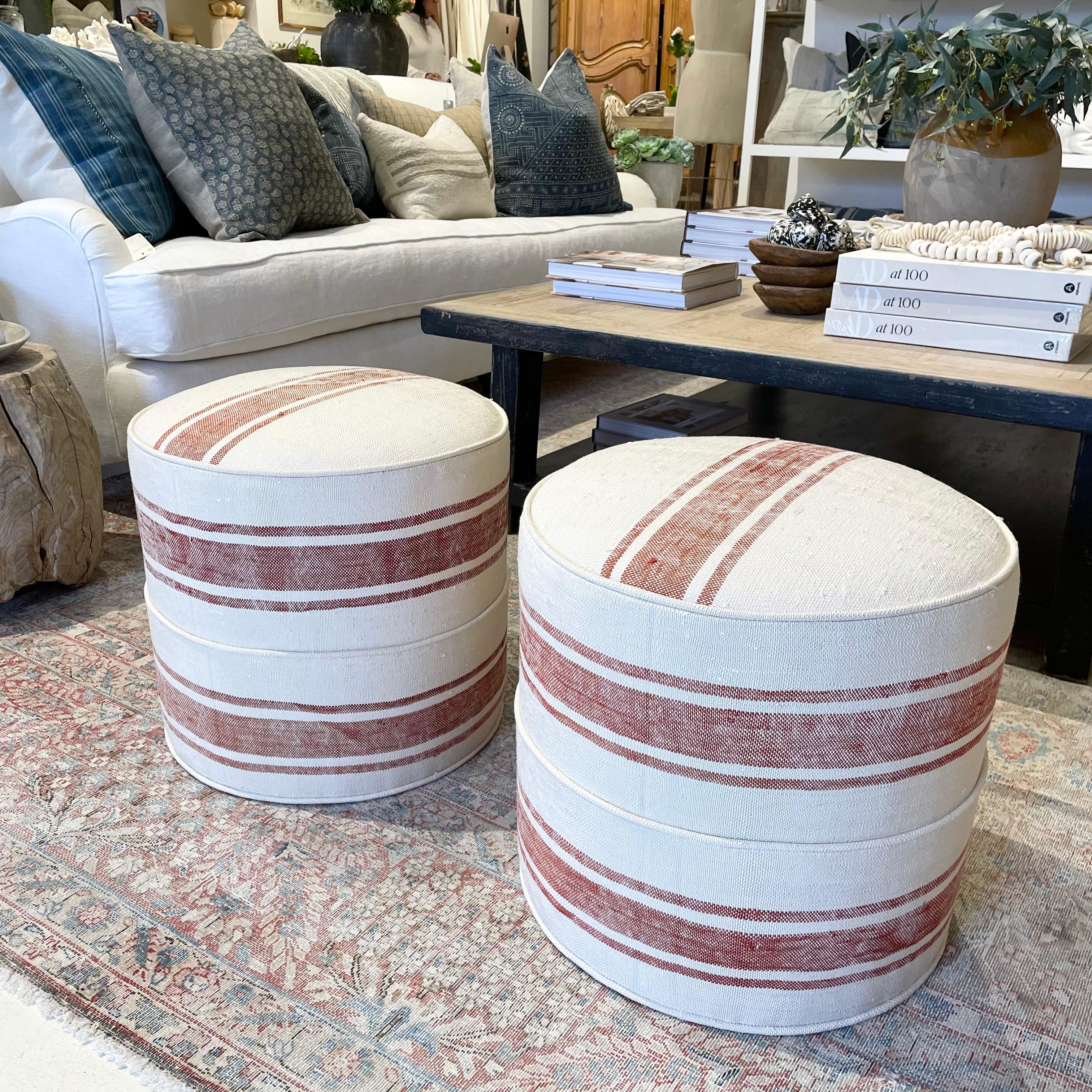 Custom made round ottomans from a woven Sabra silk rug 
The background is a creamy white, with burnt orange color stripe.
These custom ottomans hold their shape, and are custom made with a wood frame, foam top in a medium firm density.
Size: 18”