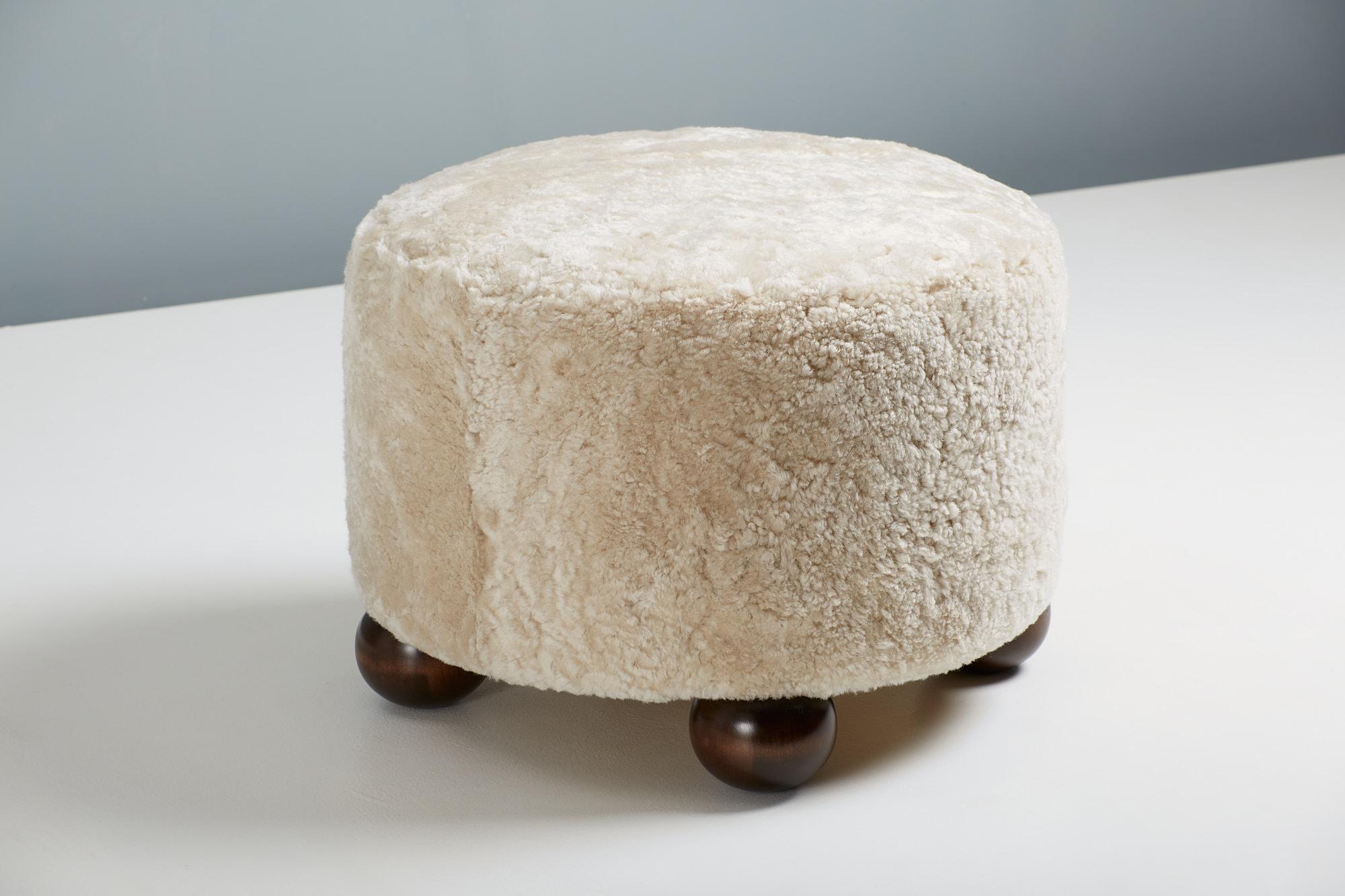 Pouf sur mesure développé et produit dans nos ateliers à Londres en utilisant des matériaux de la plus haute qualité. Cet exemple est tapissé de peau de mouton crème 