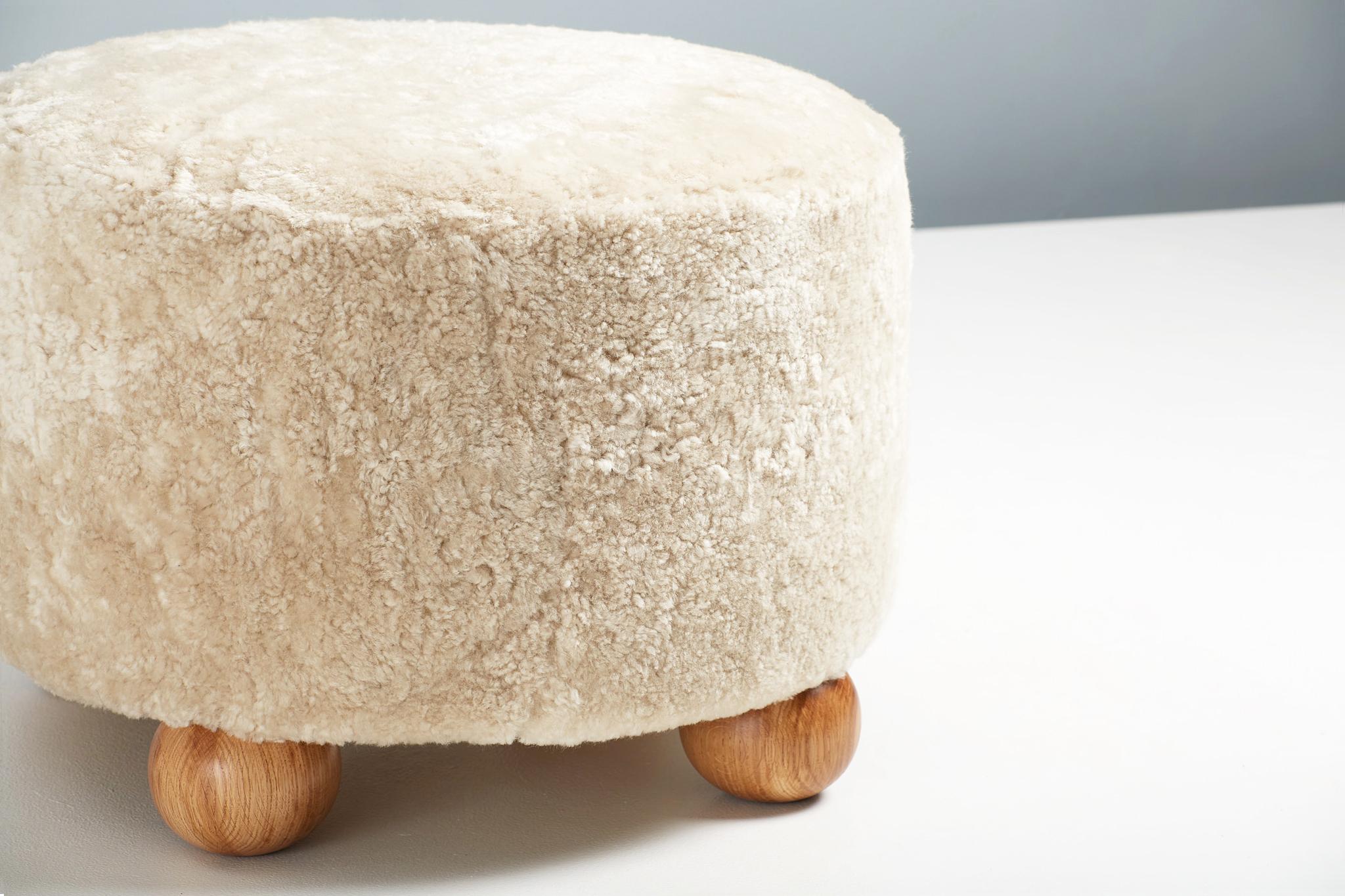 XXI secolo e contemporaneo Ottomana rotonda in pelle di pecora su misura con piedi a sfera in Oak, (COM) in vendita