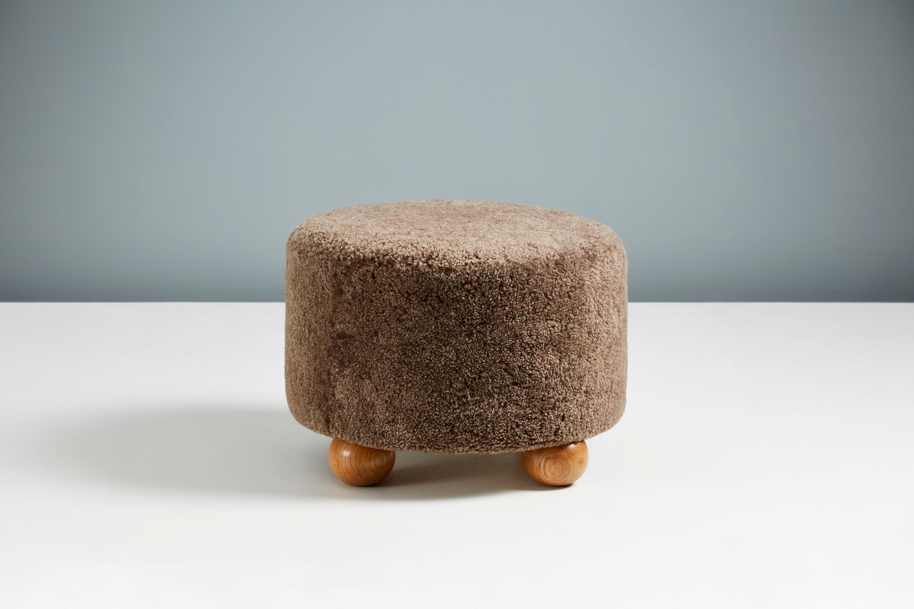 Custom-made ottomans developed & produced at our workshops in London using the highest quality materials. These examples are upholstered in a warm grey sheepskin and feature oiled oak ball feet.
 