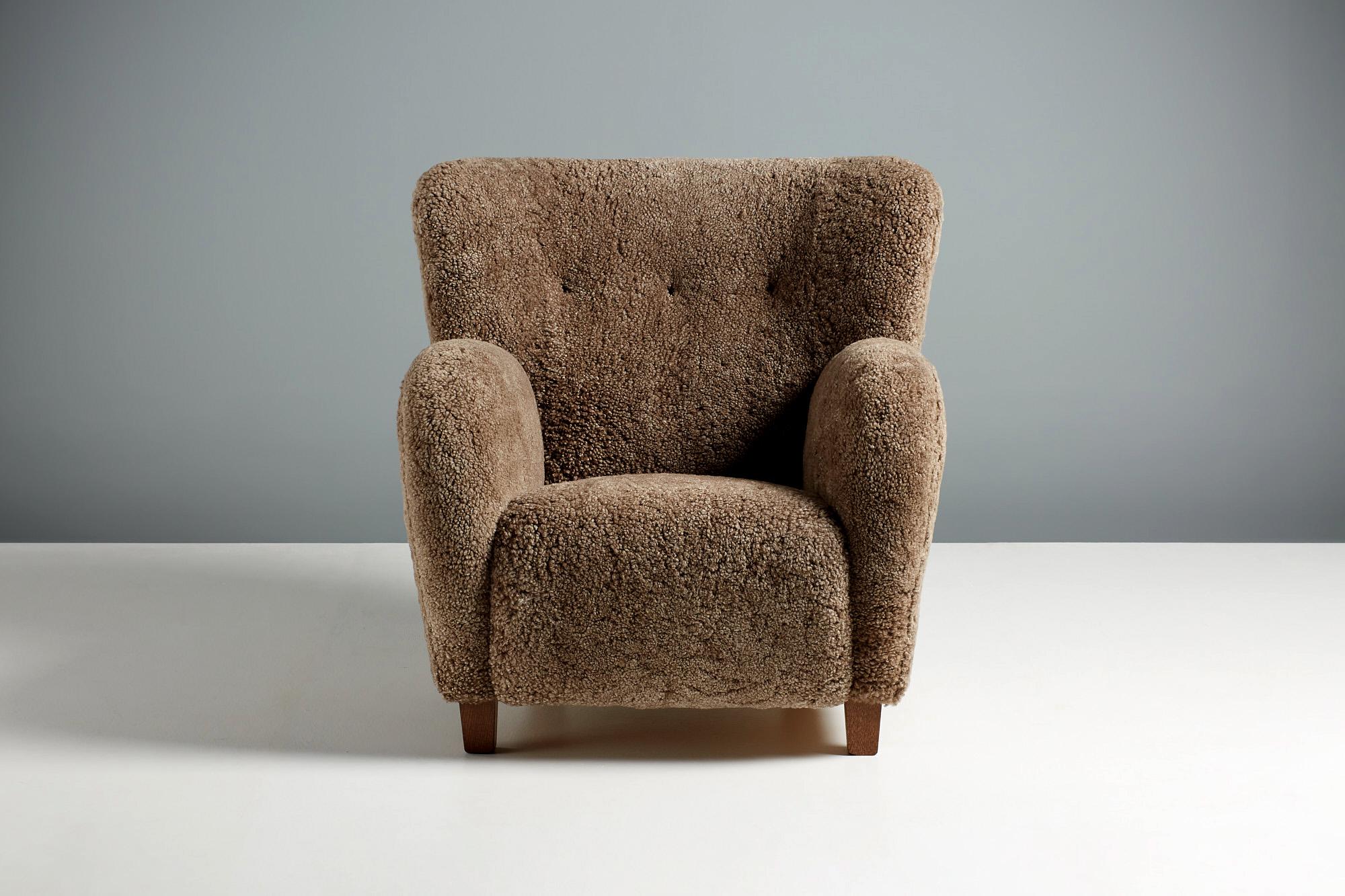 Dagmar Karu Sessel und Ottomane aus braunem Shearling mit Beinen aus geräucherter Eiche. 

Diese Sessel werden auf Bestellung in unseren Werkstätten in England handgefertigt. Die Stuhlbeine sind in geölter Eiche, Räuchereiche oder Nussbaum