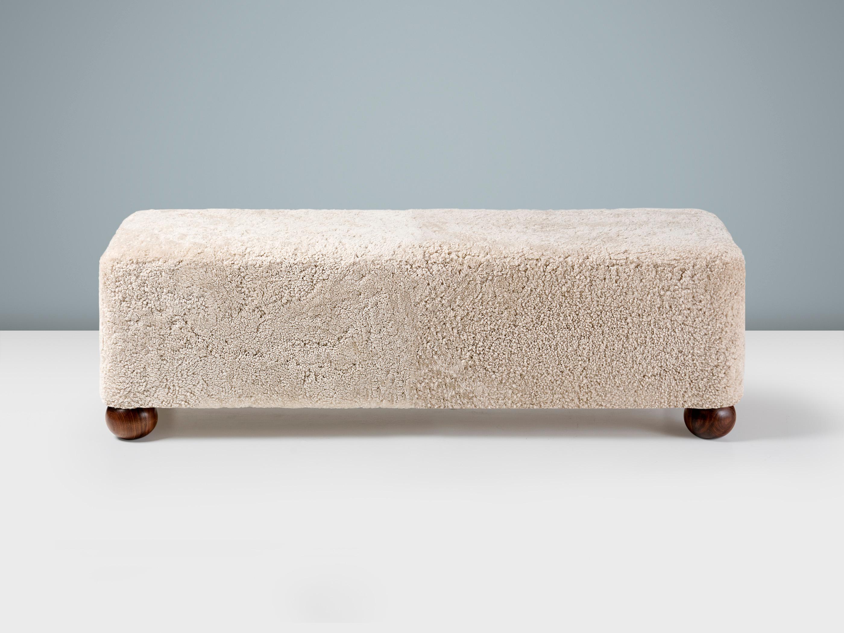 Una panca con pouf lunga realizzata su misura che offre un'opzione di seduta versatile e sofisticata per qualsiasi interno moderno. I solidi piedi a sfera sono disponibili in 3 finiture, tra cui il noce oliato mostrato qui. Il pouf è perfetto per un