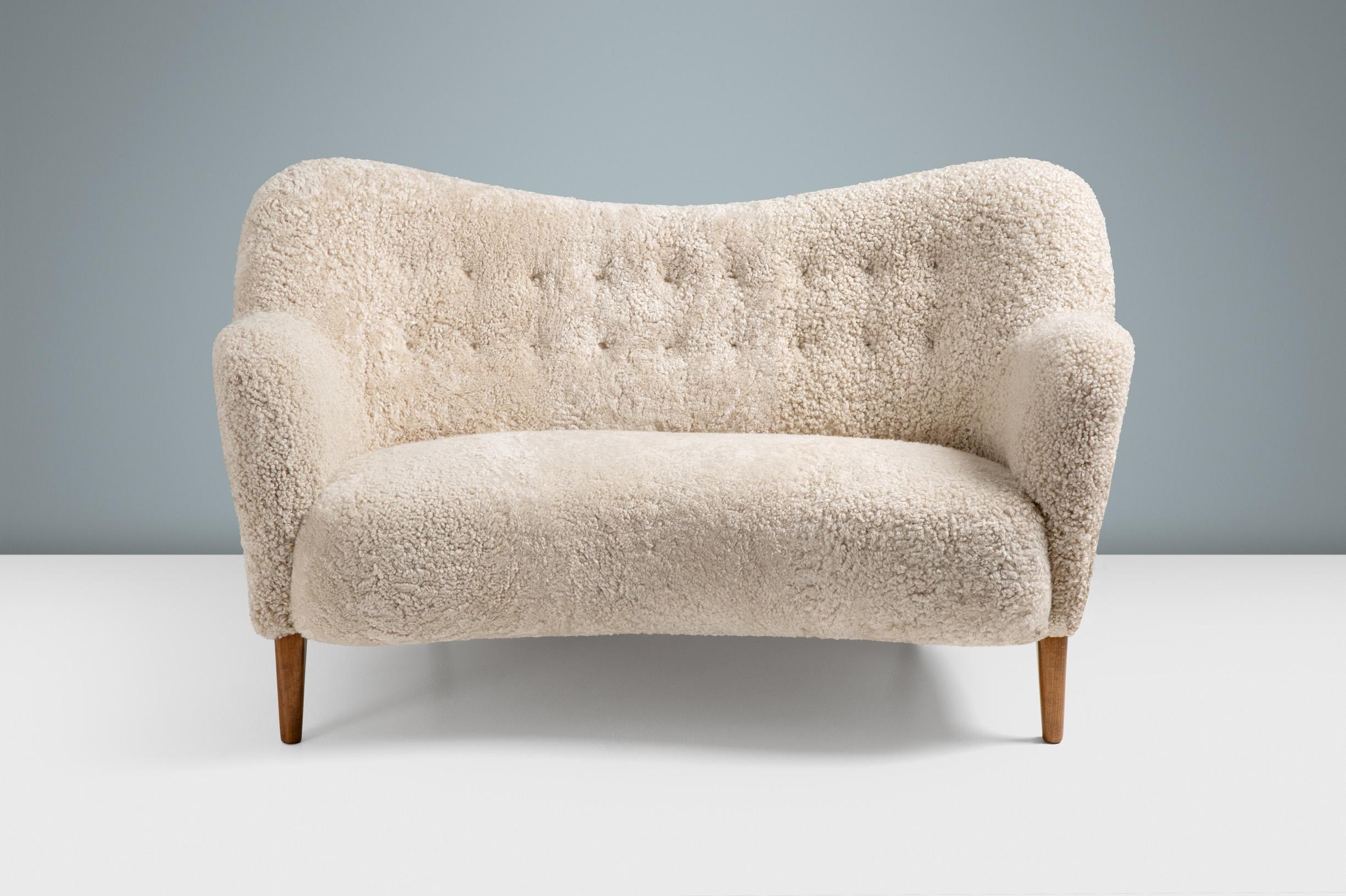 A custom-made new edition of this classic love-seat sofa by Danish designer and cabinetmaker: Alfred Kristensen. This re-edition is produced under license in Sweden by Dagmar and available to order in a range of upholstery and wood