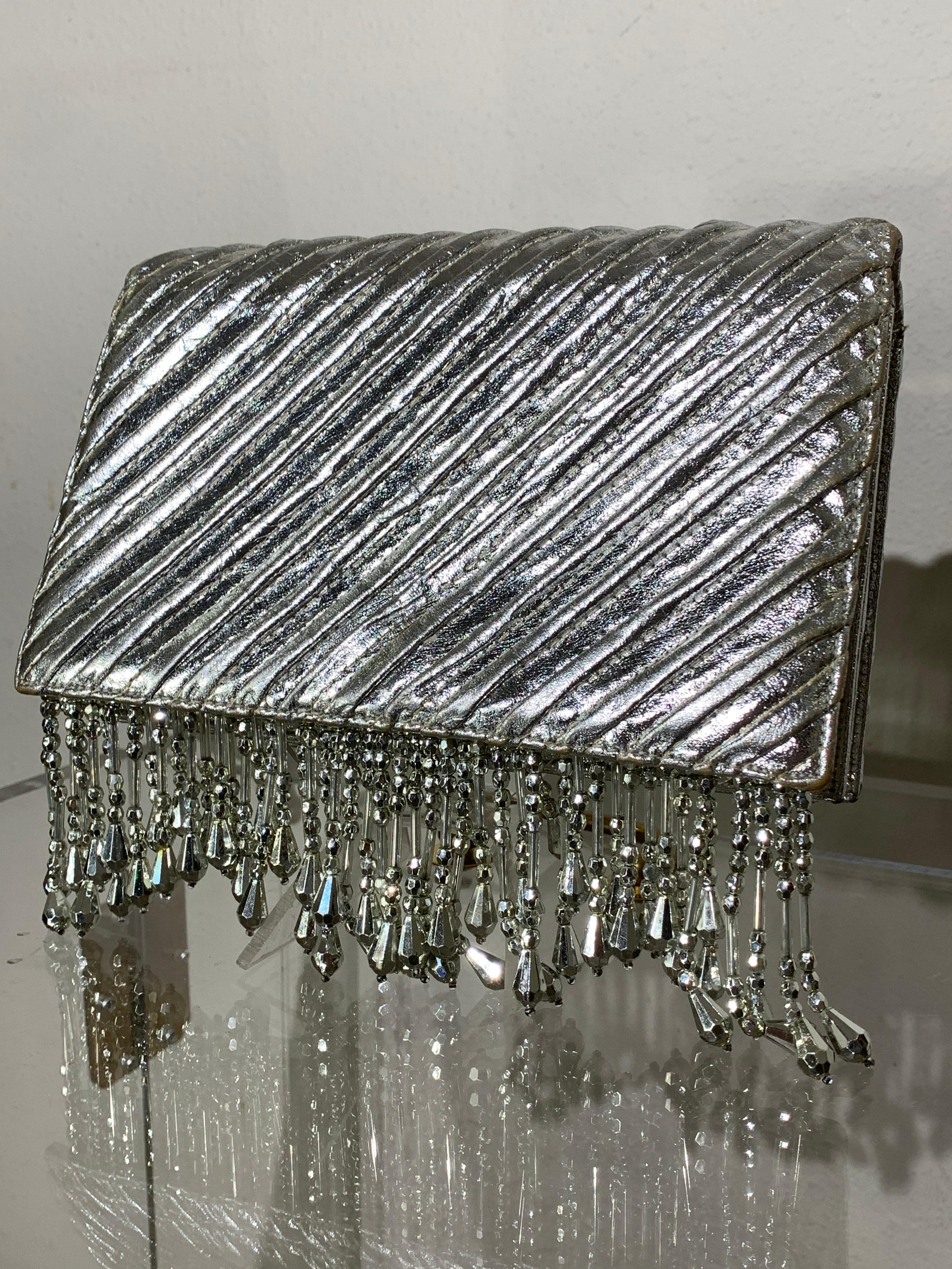 Pochette enveloppante en cuir métallisé matelassé argenté sur mesure avec frange en perles argentées :  Une pochette de déclaration fabuleusement extravagante fait une entrée remarquée !  Fermeture par bouton-pression. Doublée en crème avec de fines