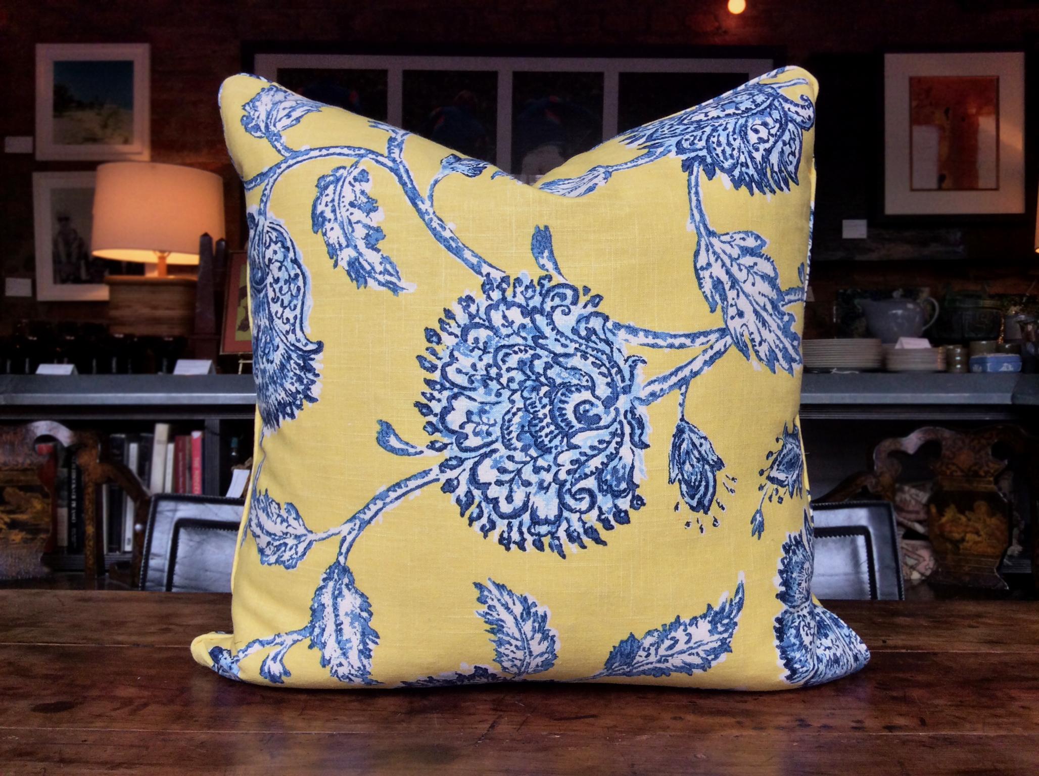 A custom made square pillow with a rich, beautiful palette and patterning. The fabric is 100% cotton. It's an exclusive Duralee print textile in a yellow and blue colorway. Whimsical flowers rendered in blue and white adorn a bright yellow ground.