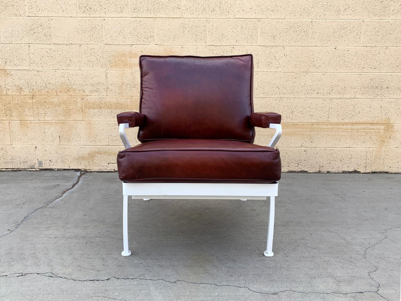 What a beauty! Our custom made steel and leather armchair features a gloss white powder coated frame with leather upholstery in deep burgundy. Seat back is vinyl. Sleek atomic styling compliments a variety of interior styles from art deco, to mid