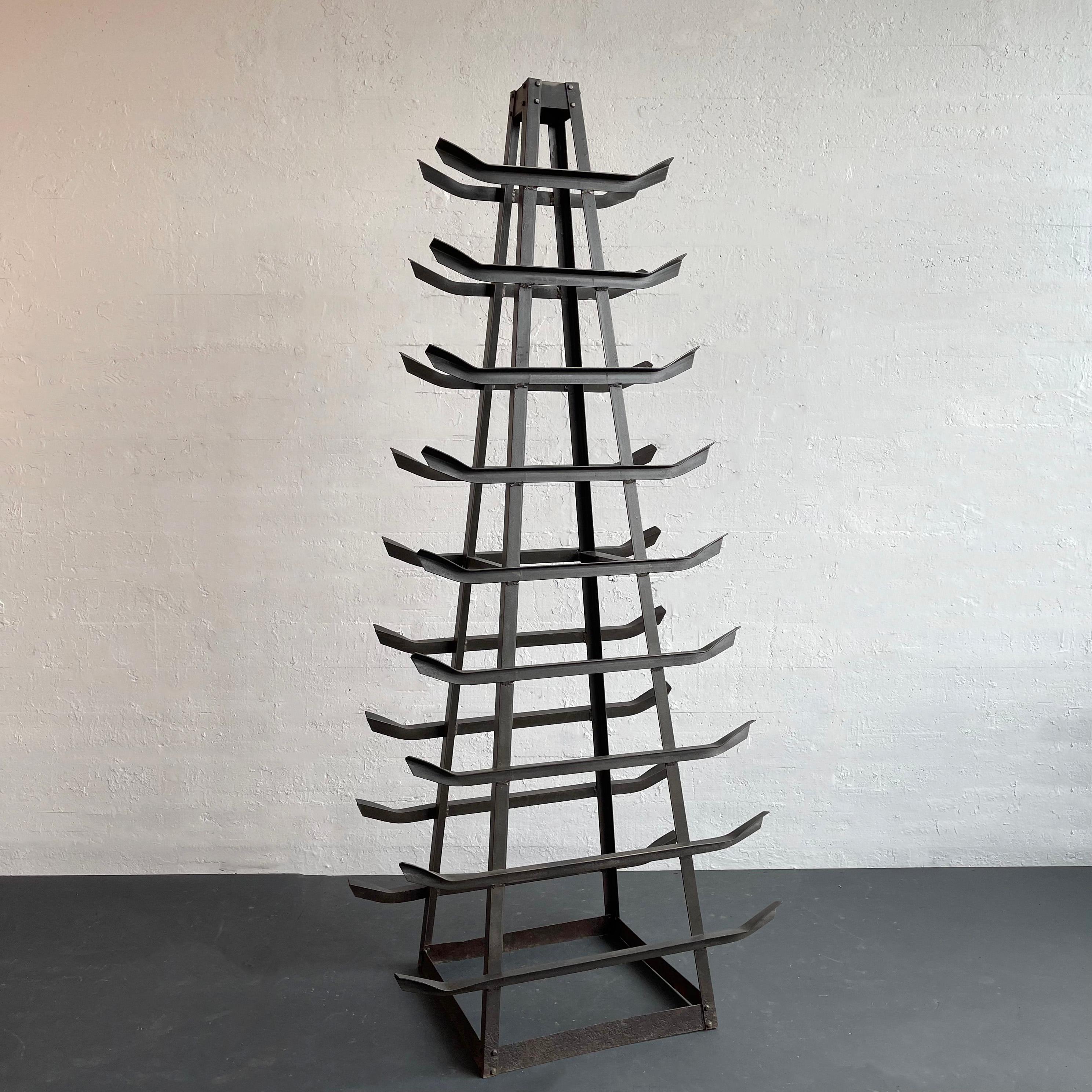 Questa torre in ghisa alta, realizzata su misura, è composta da 9 livelli di scaffali rovesciati che si assottigliano fino a raggiungere i 22 pollici x 8 pollici dello scaffale superiore. La torre è un pezzo unico di magazzino industriale,