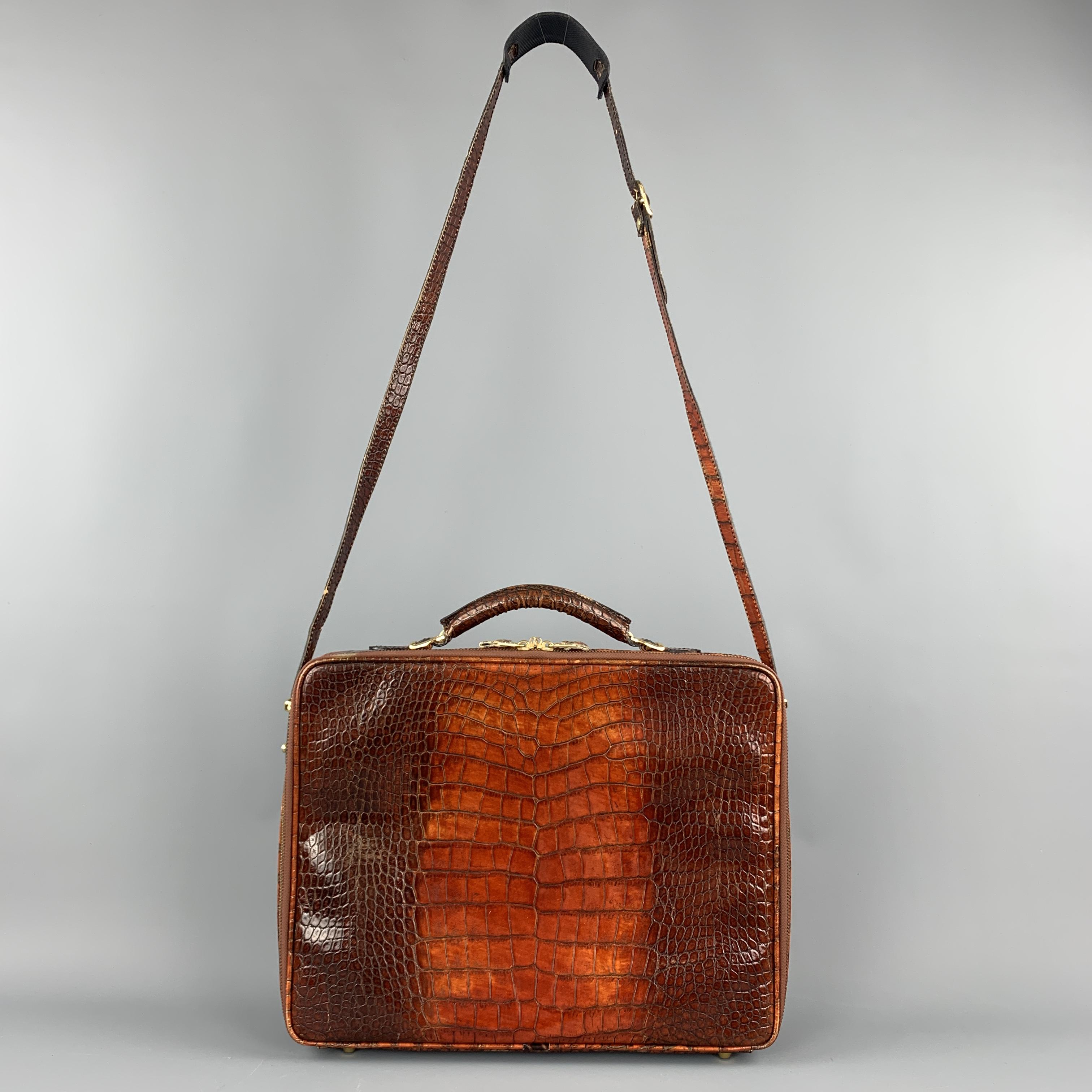 Custom made briefcase comes in tan to brown ombre effect alligator embossed patent leather with a buckled top handle, zip pocket, detachable strap, zip around closure, and multi compartment interior with pockets. Made in Italy.

Very Good Pre-Owned