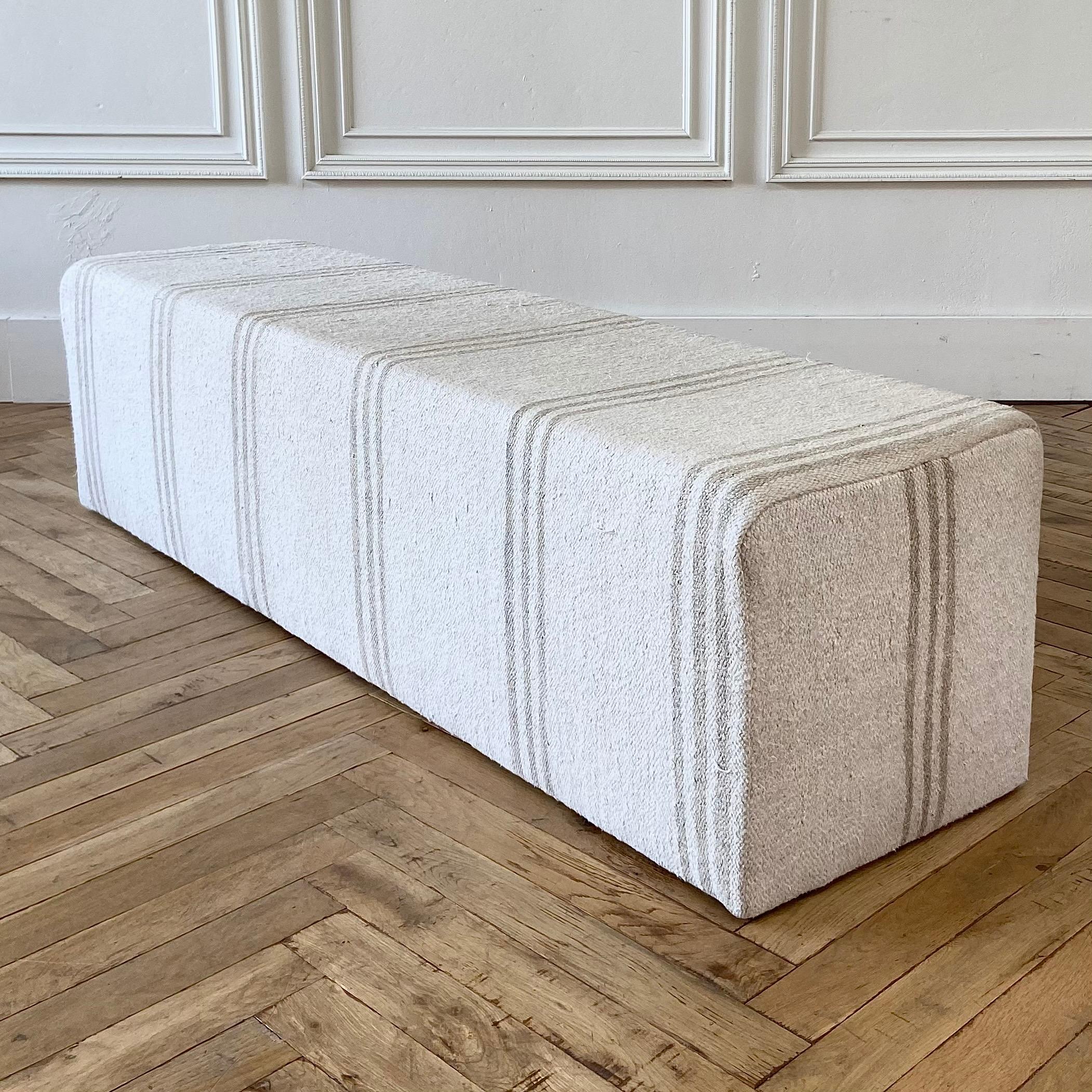 Custom Made Turkish rug Cube style long bench ottoman
A pretty light natural/ off white colored rug with faded taupe gray stripes.
This custom made ottoman bench is perfect as an end of the bed bench, or entry, or living room.
The wood frame