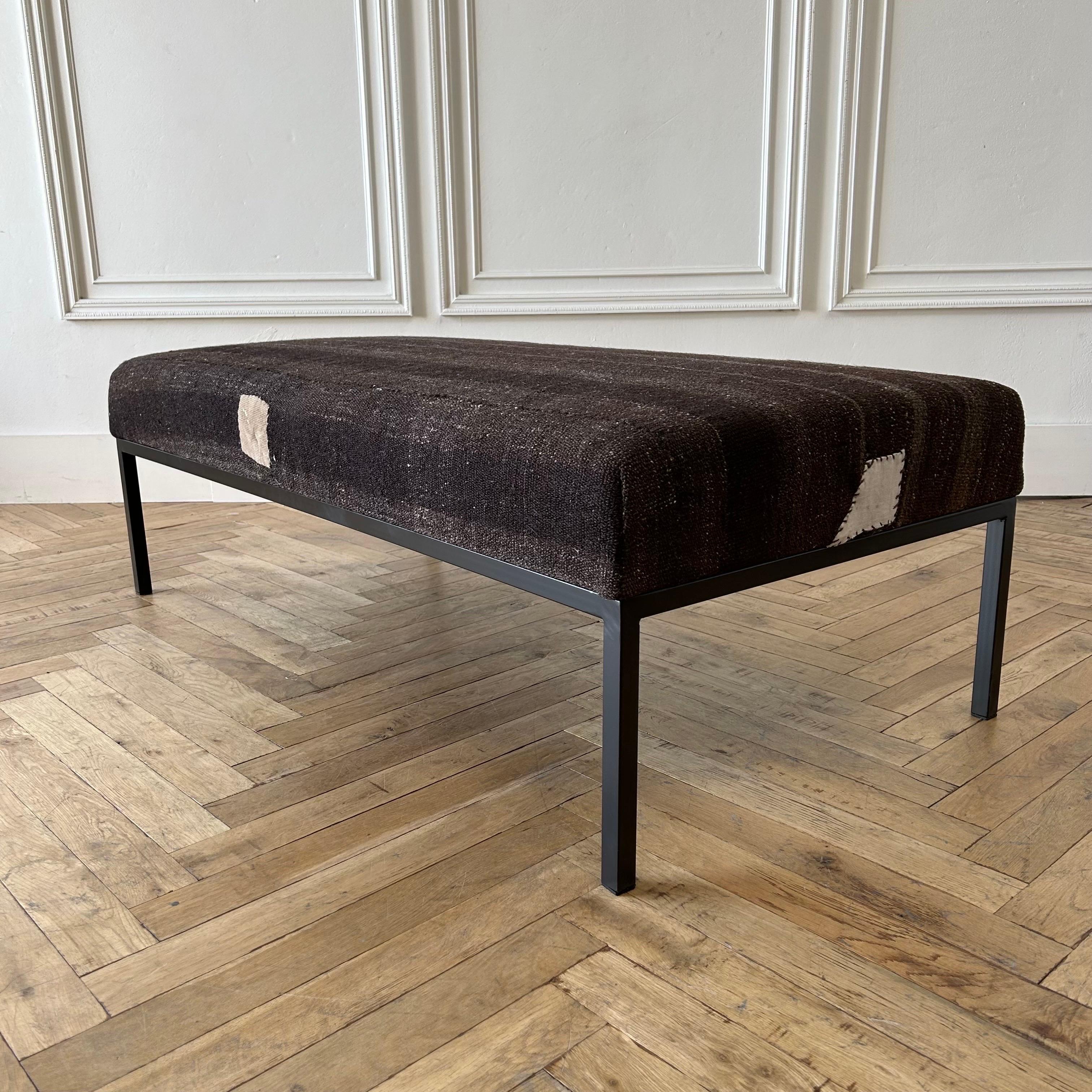 Custom made bench ottoman by Bloom Home Inc.
Size: 56”w x 28”d x 18”h
Custom made metal base, and powder coated in a dark iron bronze finish.
The upholstered top is from an antique or vintage Turkish rug.

Color: brown/coco/taupe/original beige